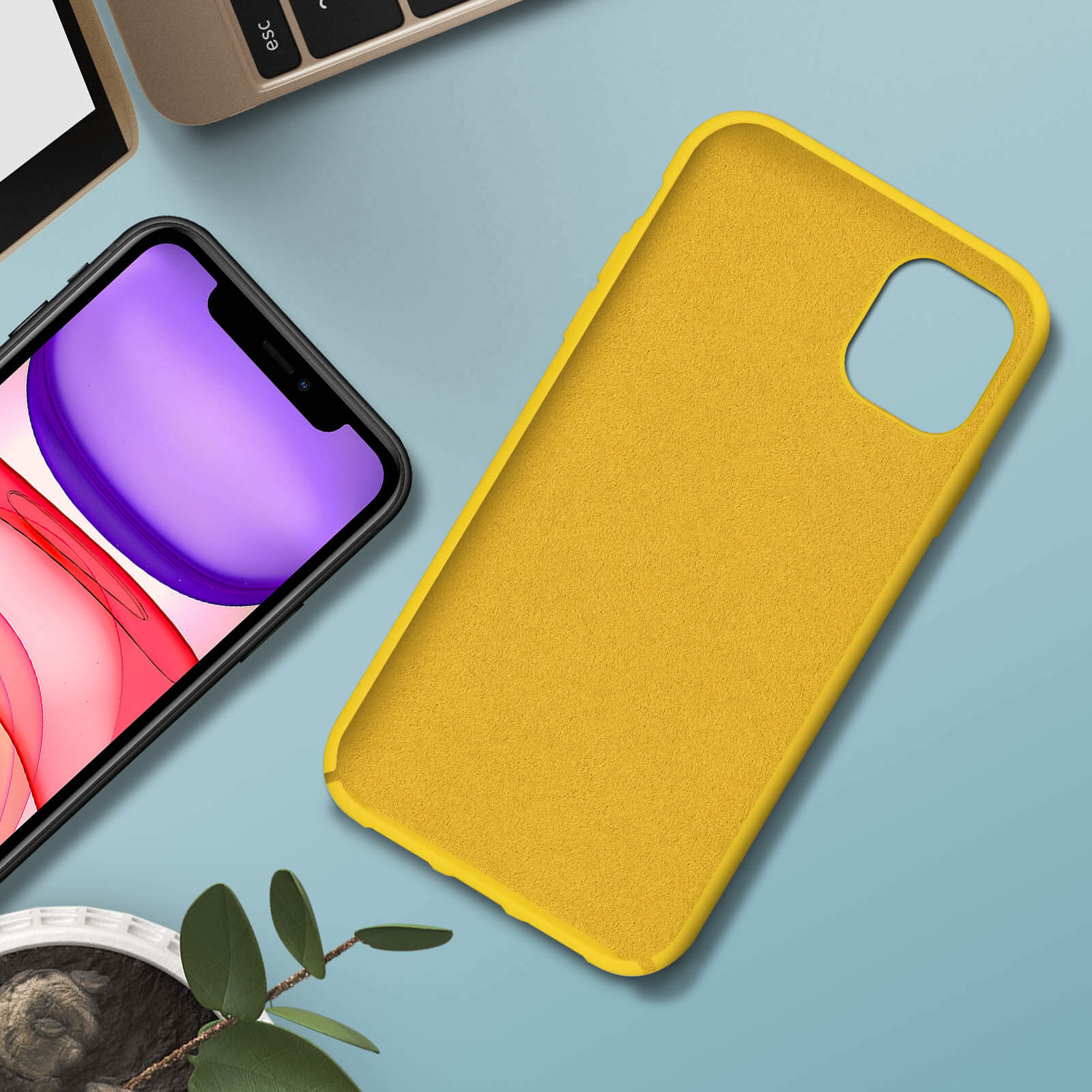 Une coque de téléphone jaune sur une surface, avec un téléphone à l'intérieur, près de feuilles.