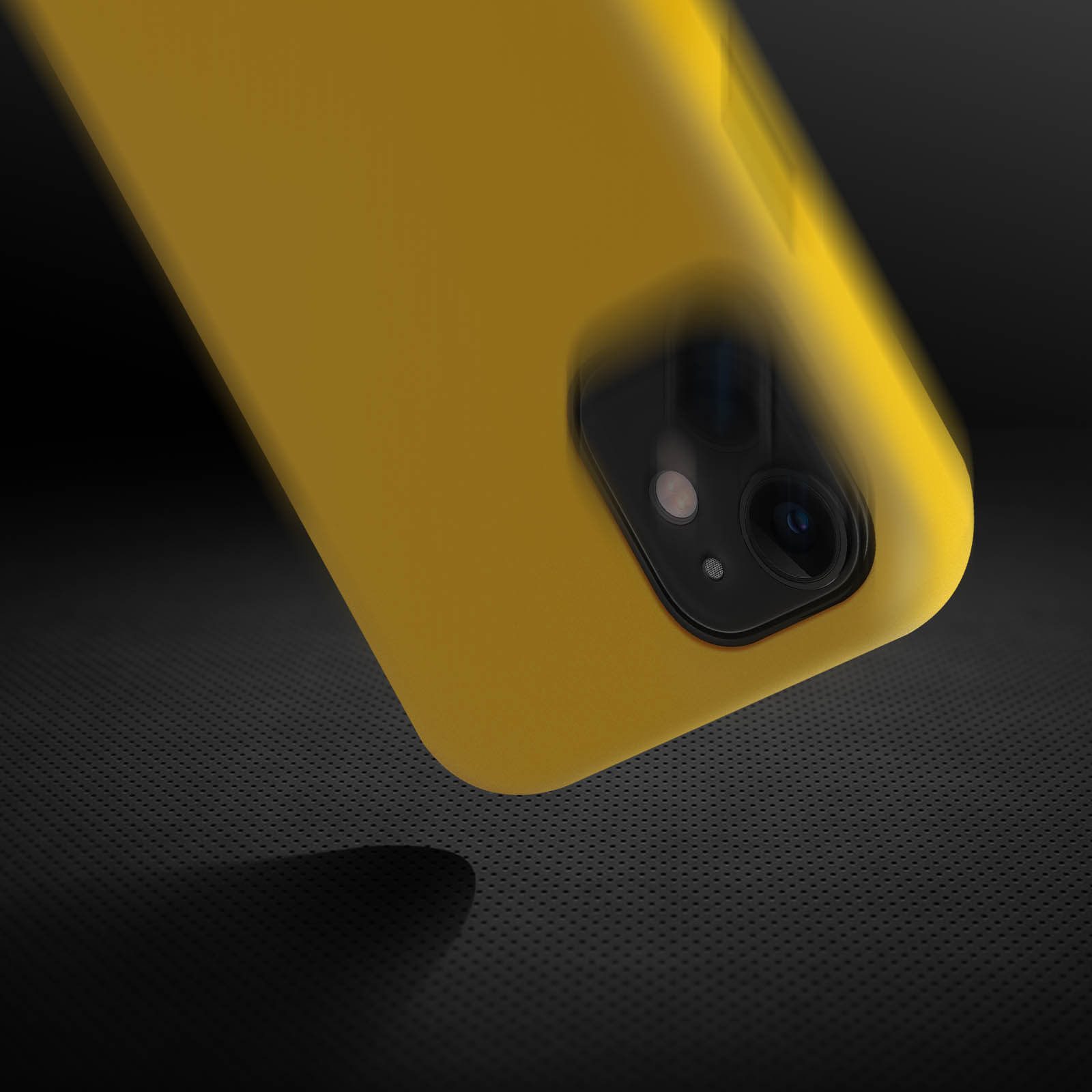 Coque de téléphone jaune avec bosse de caméra sur surface sombre texturée, suggérant une chute.