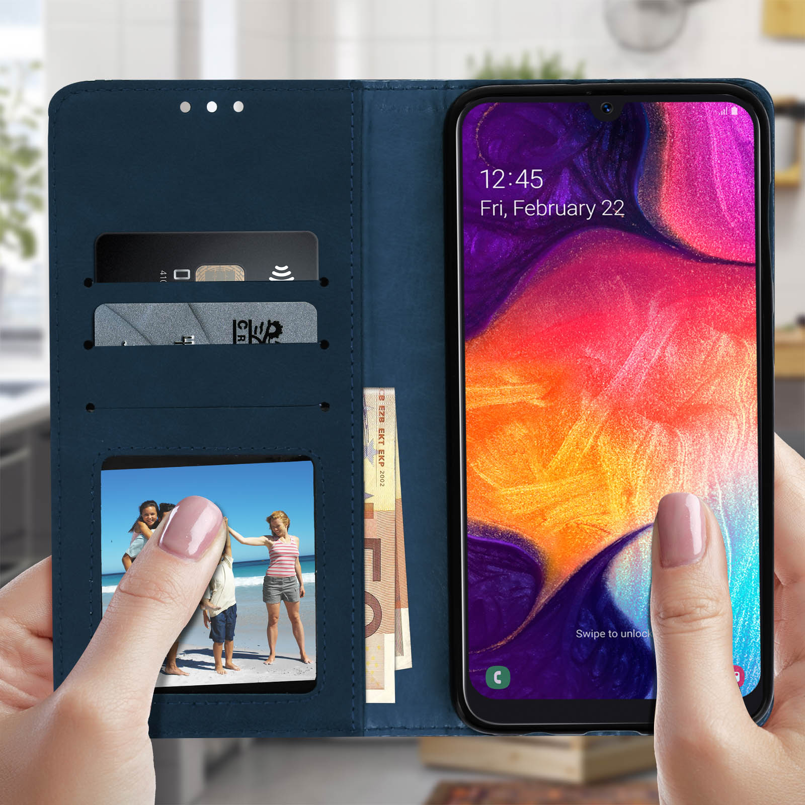 Mani che tengono un telefono in una custodia a portafoglio blu scuro. Sono visibili carte e un'immagine.