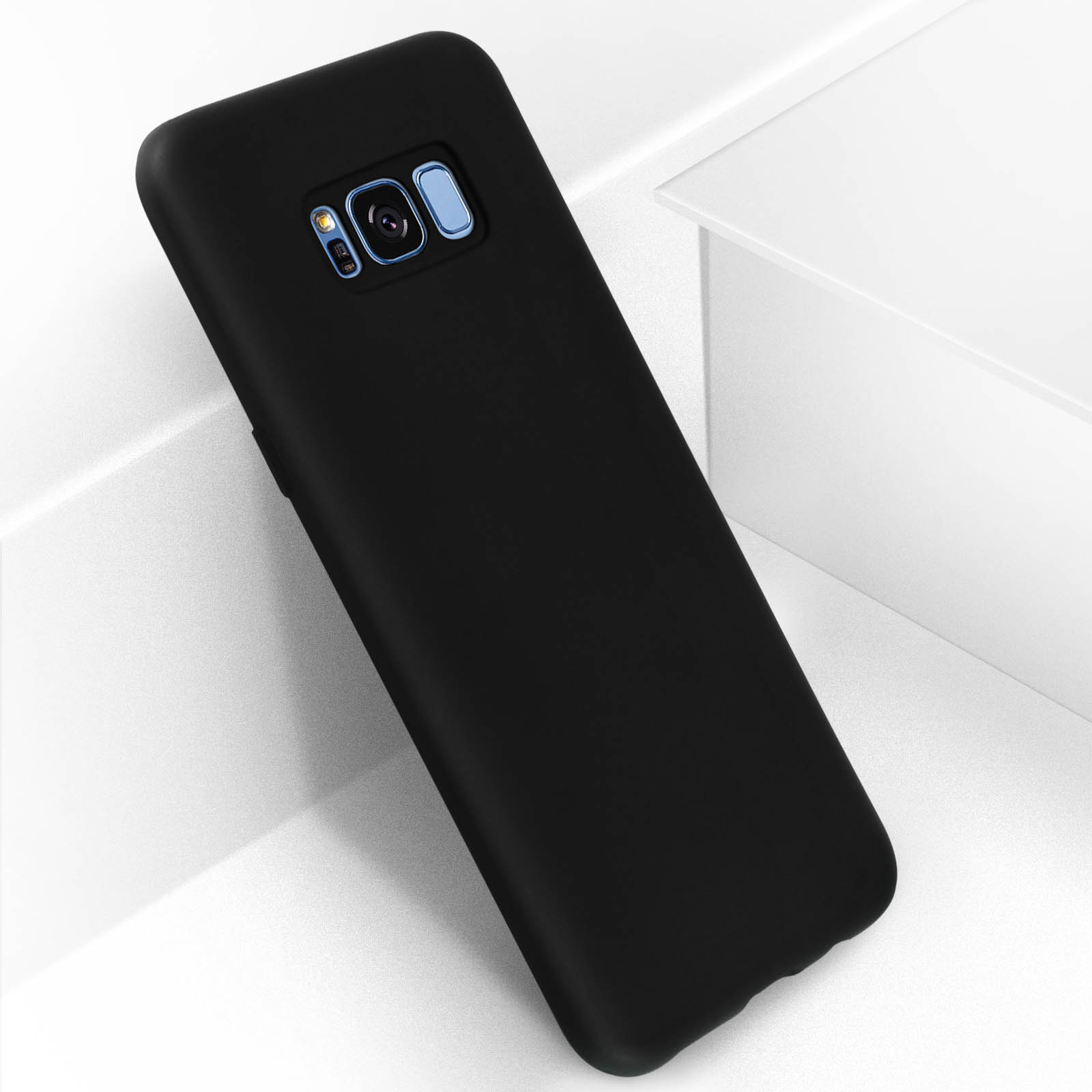 Una funda negra para teléfono sobre una superficie blanca. La funda es lisa y cubre el teléfono.