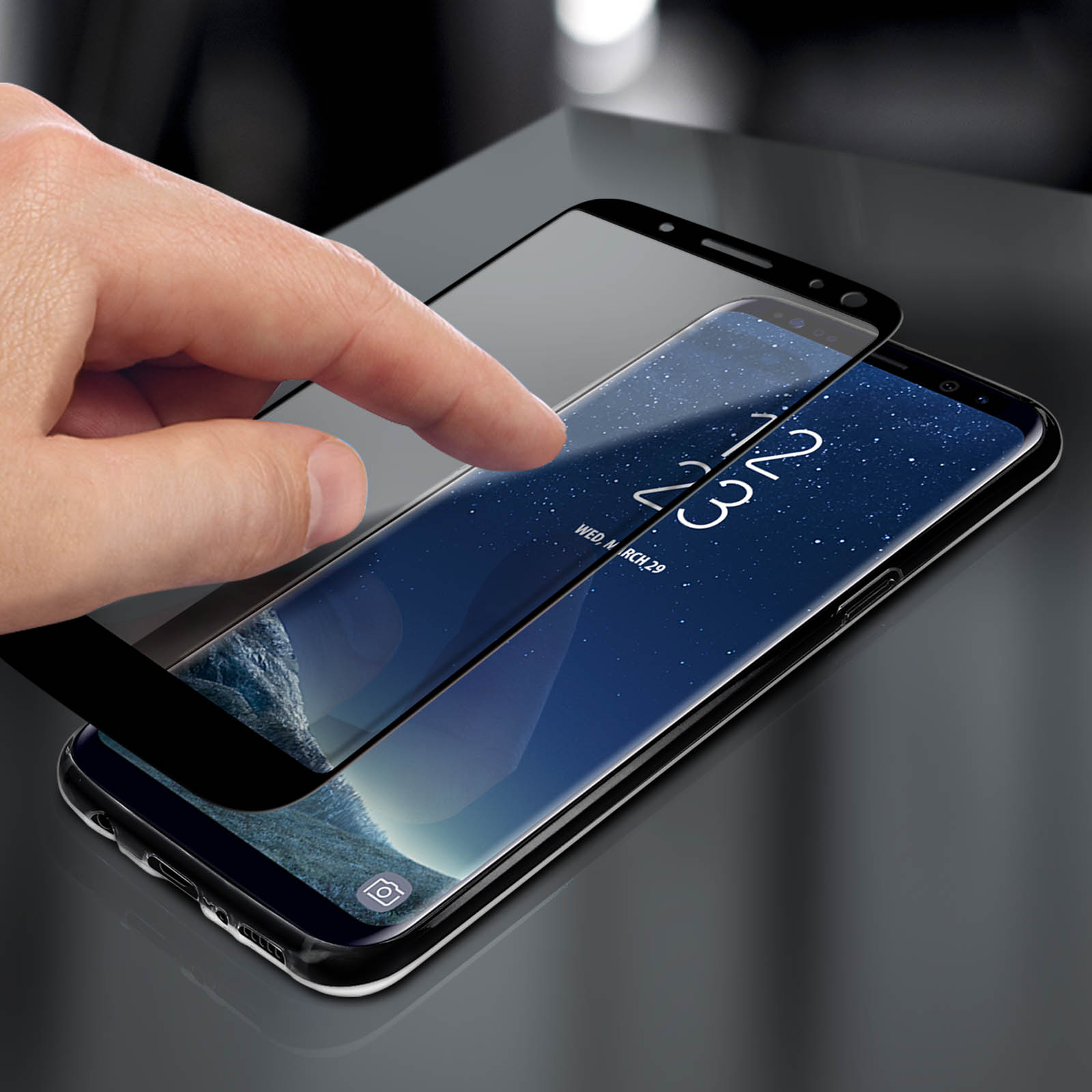 Ein Finger berührt einen Displayschutz auf einem Telefon. Das Telefon zeigt als Datum Mittwoch, 29. März.