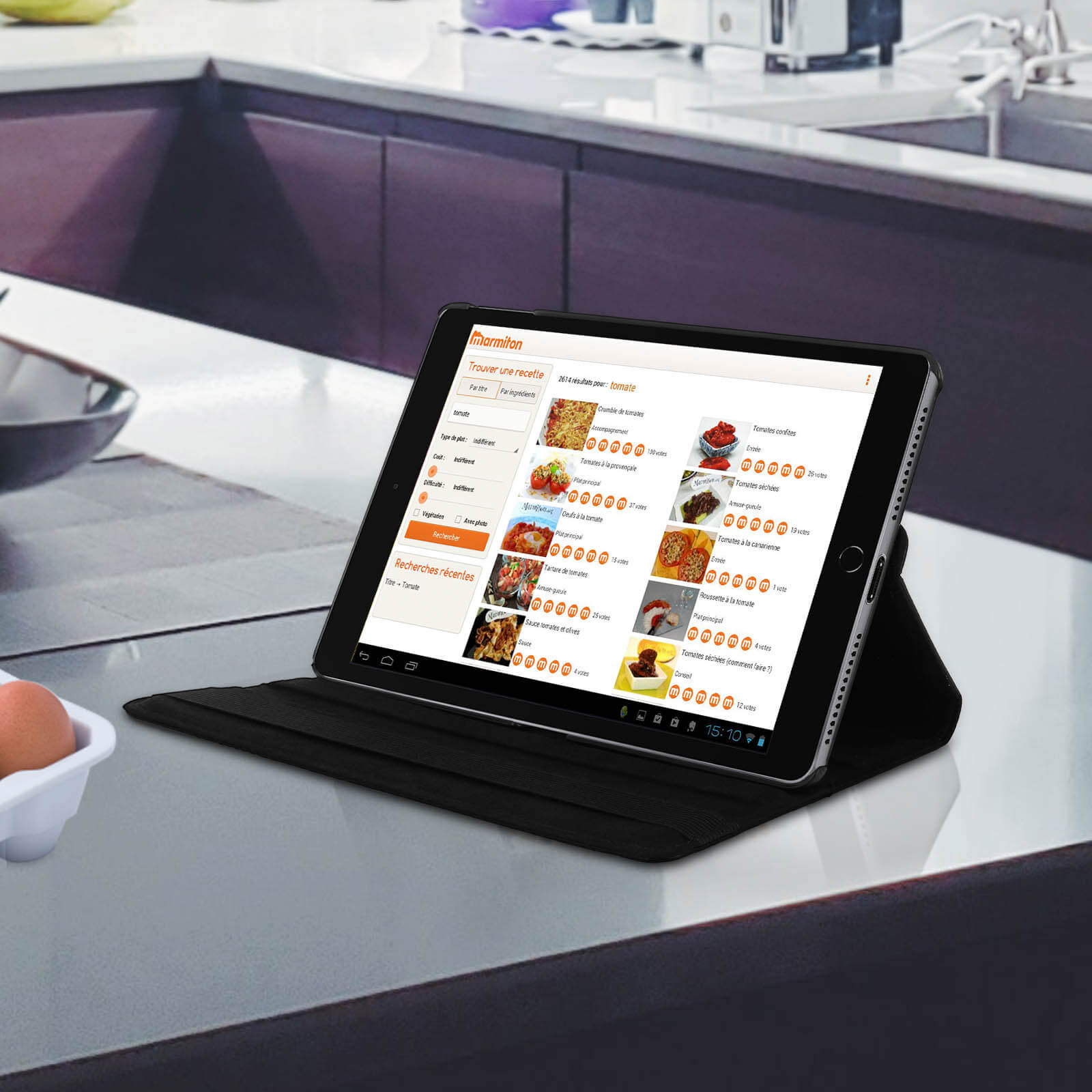 Un tablet è su un piano di lavoro, mostra un sito web di ricette. Cucina e uova sullo sfondo.
