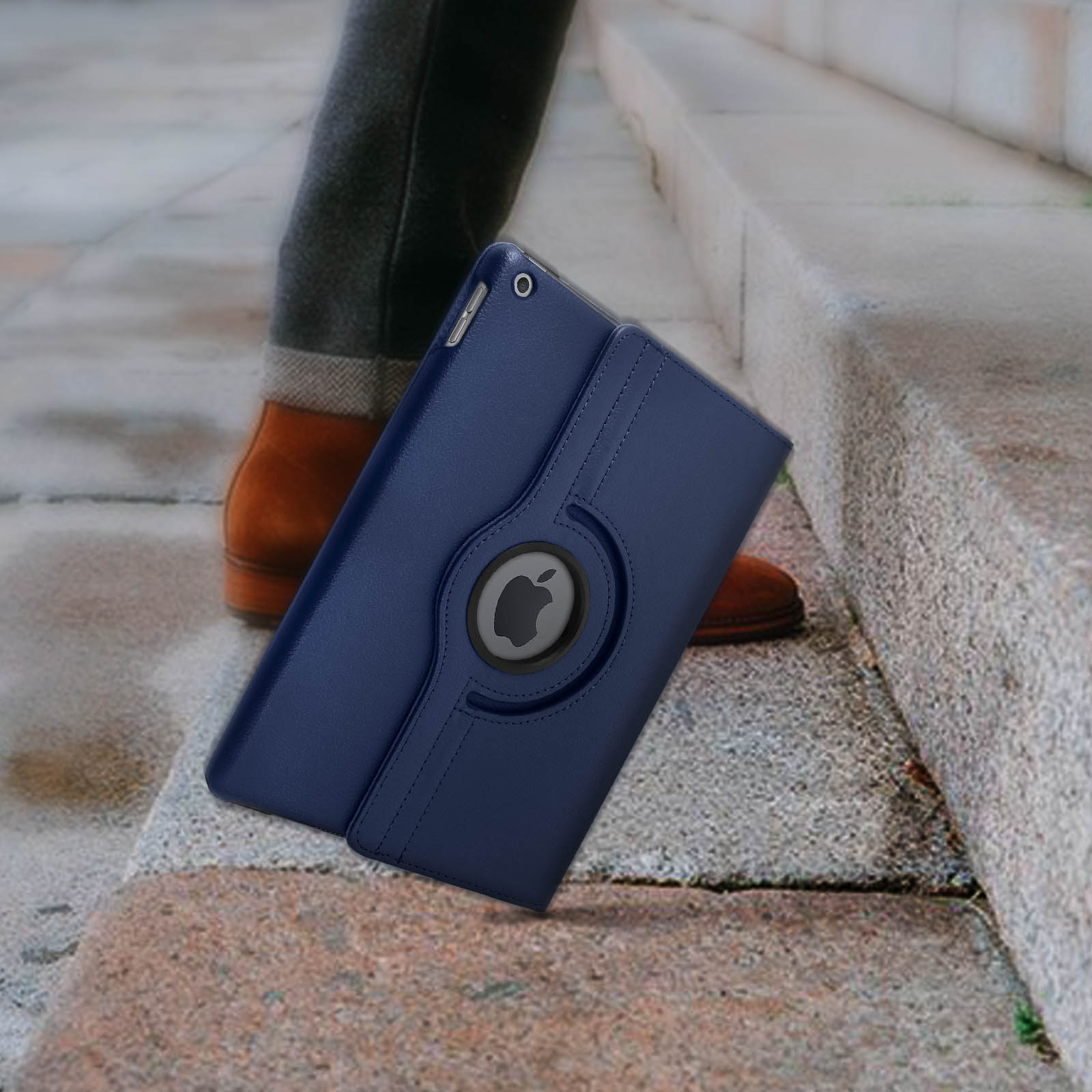 Custodia blu per iPad con logo Apple, tenuta da una persona. Scale e scarpe sullo sfondo.