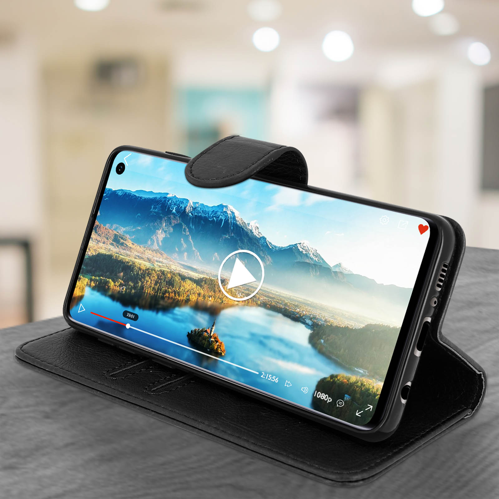Un telefono che riproduce un video su una custodia in pelle nera. Il telefono è aperto su un tavolo.