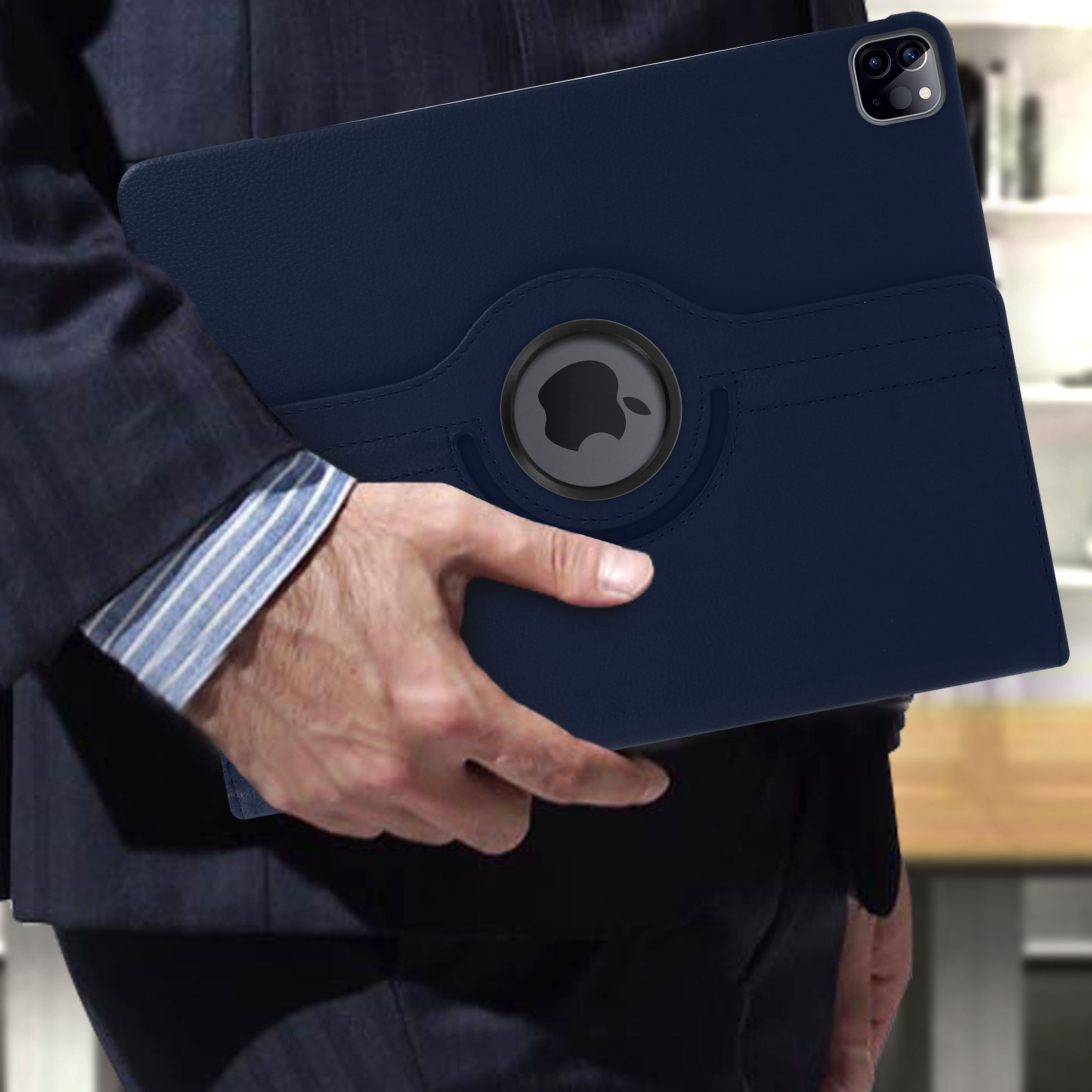 Una persona tiene una custodia per tablet blu scuro. La custodia ha un logo Apple rotante e un portapenne.
