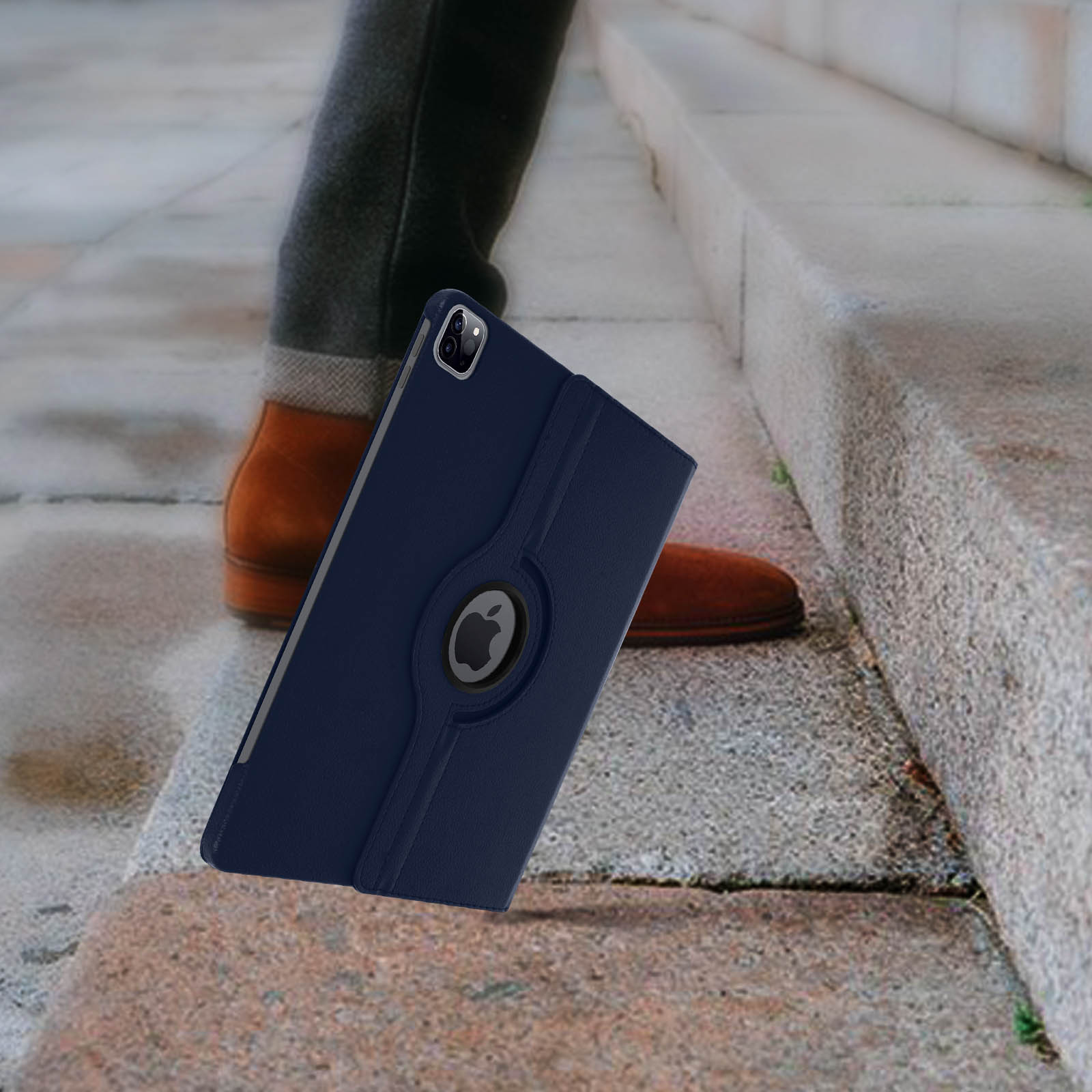Tablet in una custodia blu sulle scale. Gambe di una persona e una scarpa sullo sfondo. Gradini di pietra.