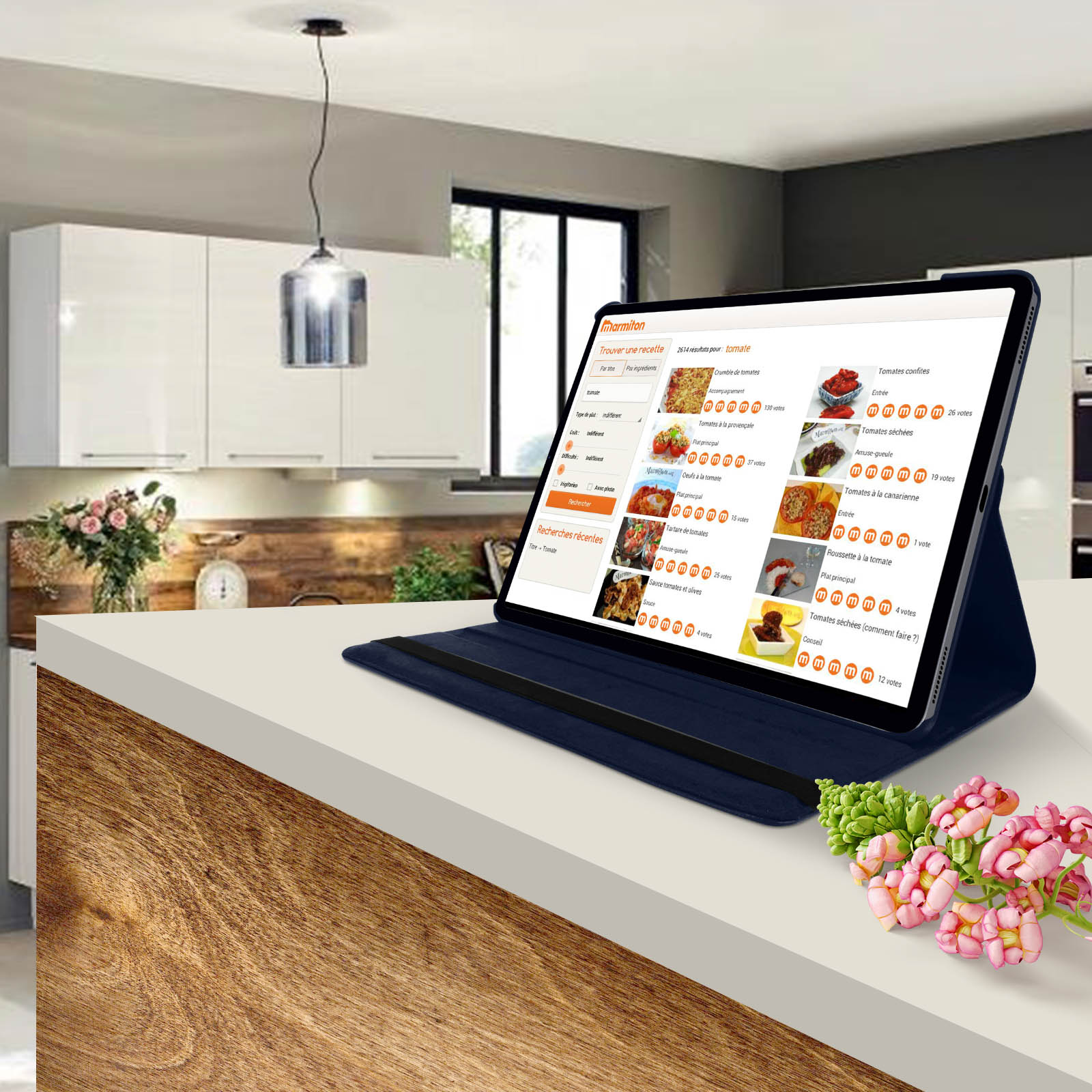 Tablet che mostra la ricerca di ricette su un piano cucina con fiori.