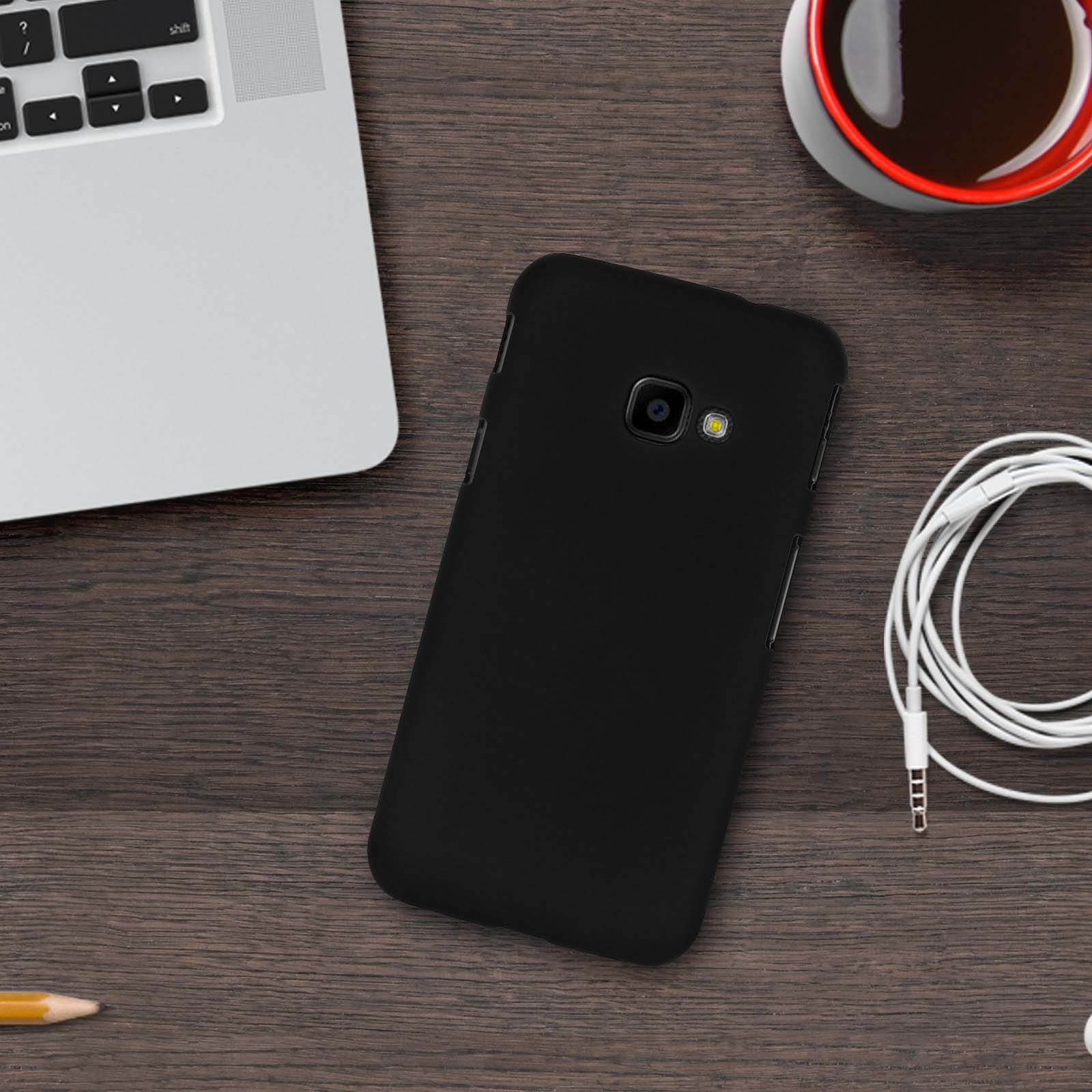 Telefono nero su una scrivania di legno con un laptop e una tazza di caffè.