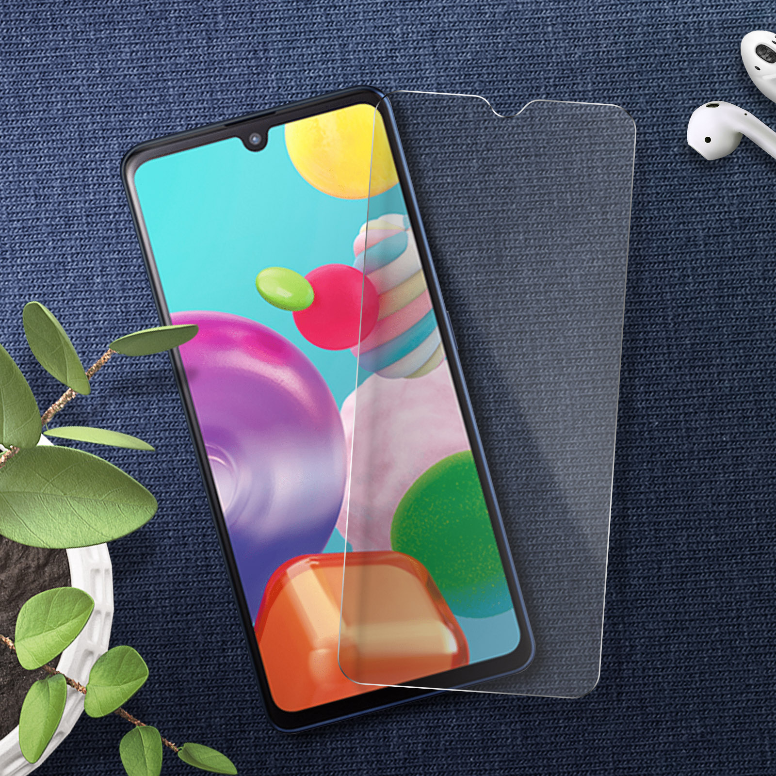 Telefono con protezione schermo. Lo schermo del telefono mostra forme colorate. Auricolari a destra.