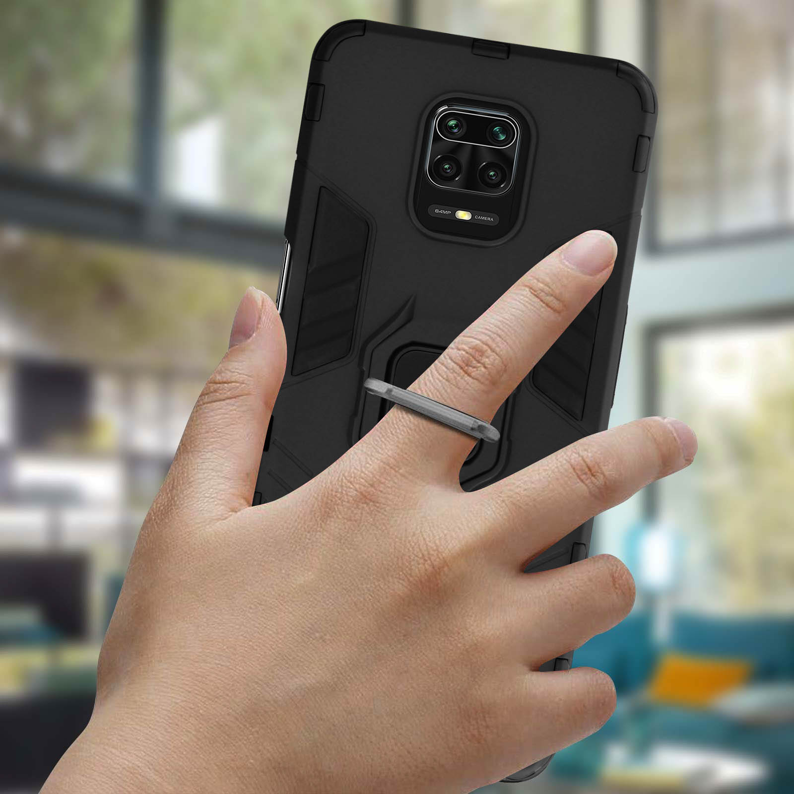 Persona che tiene in mano un telefono con un supporto ad anello attaccato. Lo sfondo è sfocato.