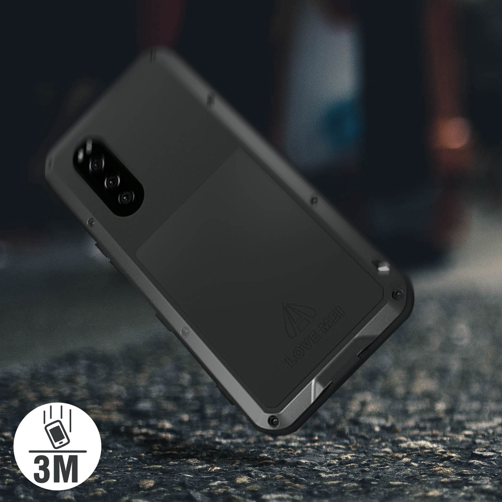 Coque de téléphone noire avec détails métalliques, sur une surface en pierre. Icône 3M dans le coin.