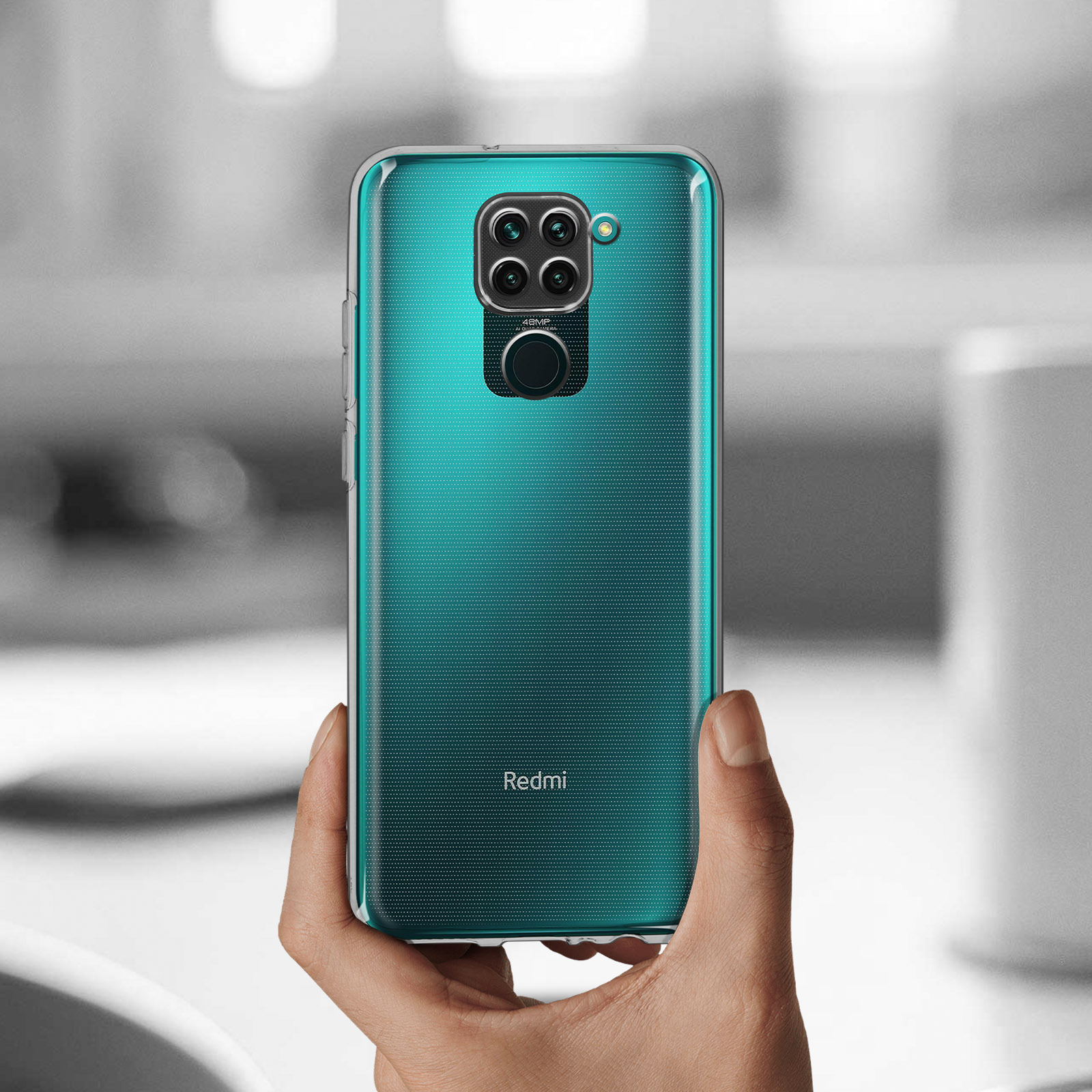 Mano che tiene una custodia trasparente con retro verde acqua. Il telefono ha una fotocamera.