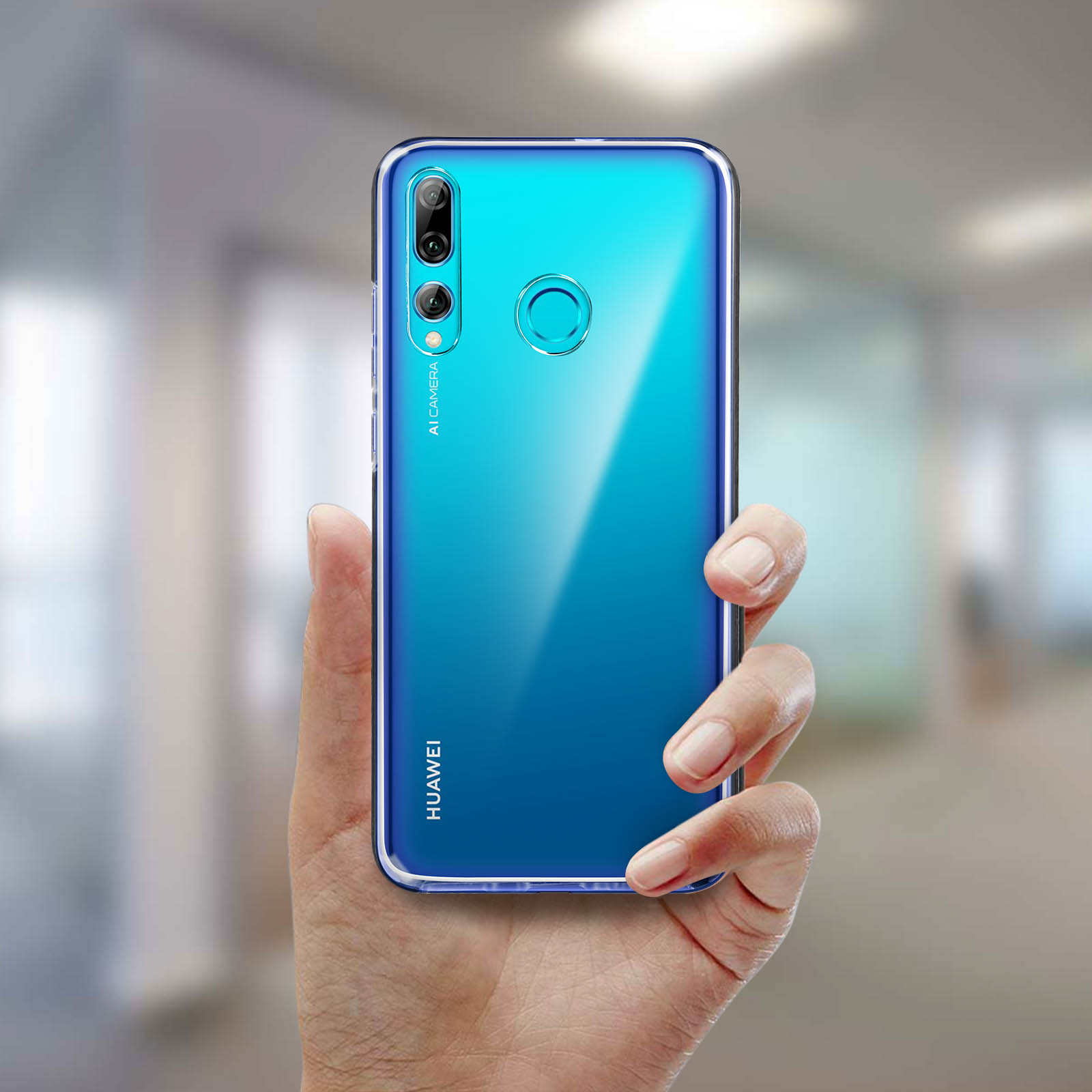 Une main tenant un téléphone dégradé bleu. Le téléphone a une coque transparente et un arrière-plan flou.