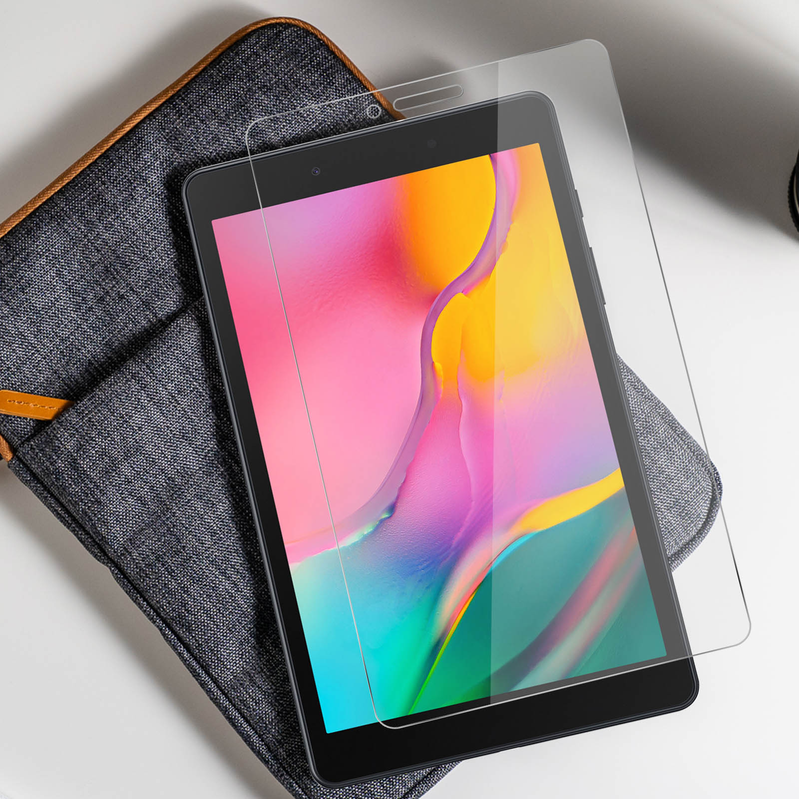 Tablet con una protezione per lo schermo, appoggiato su una custodia, vicino a una scrivania.