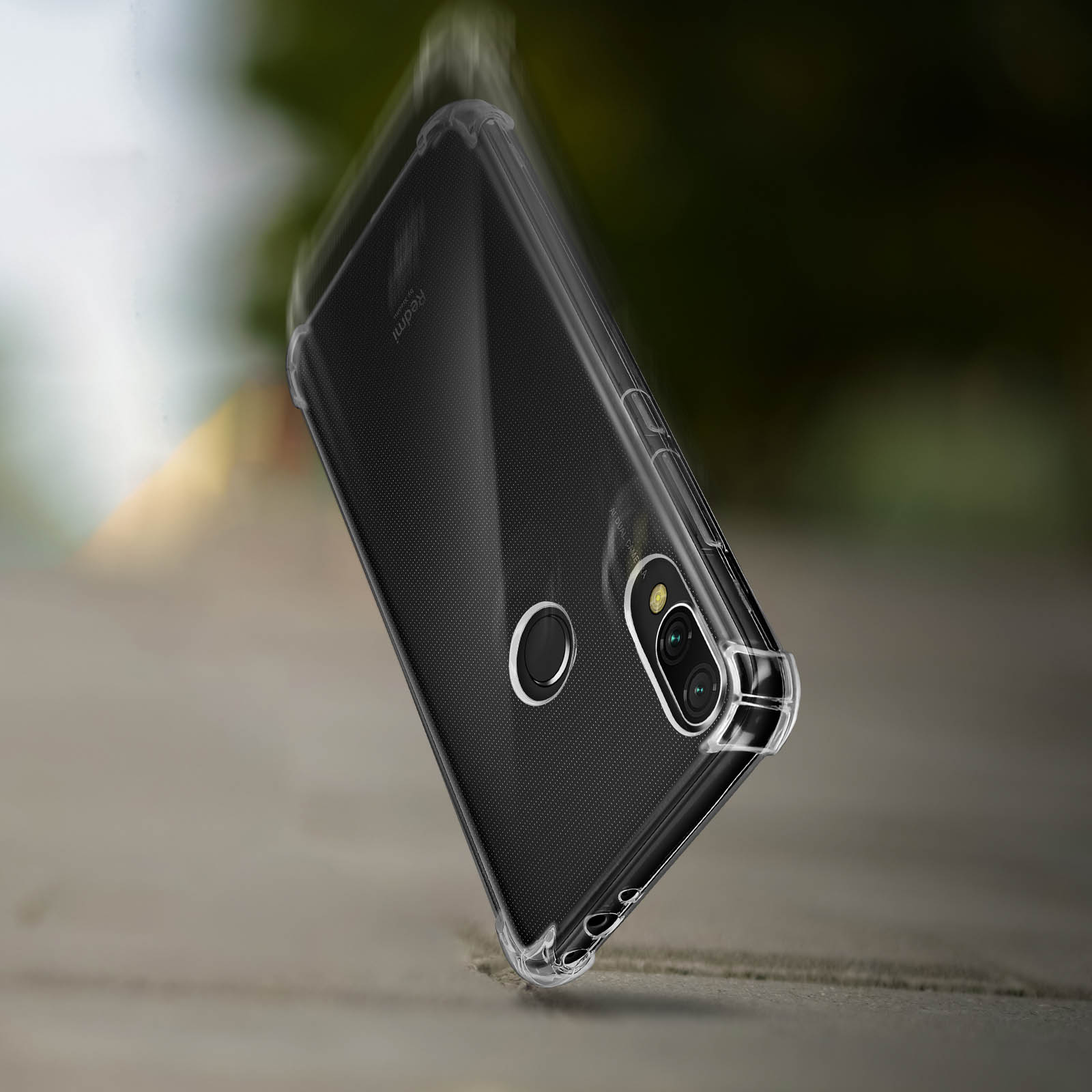 Un telefono in una custodia trasparente, che cade. Sfondo sfocato.