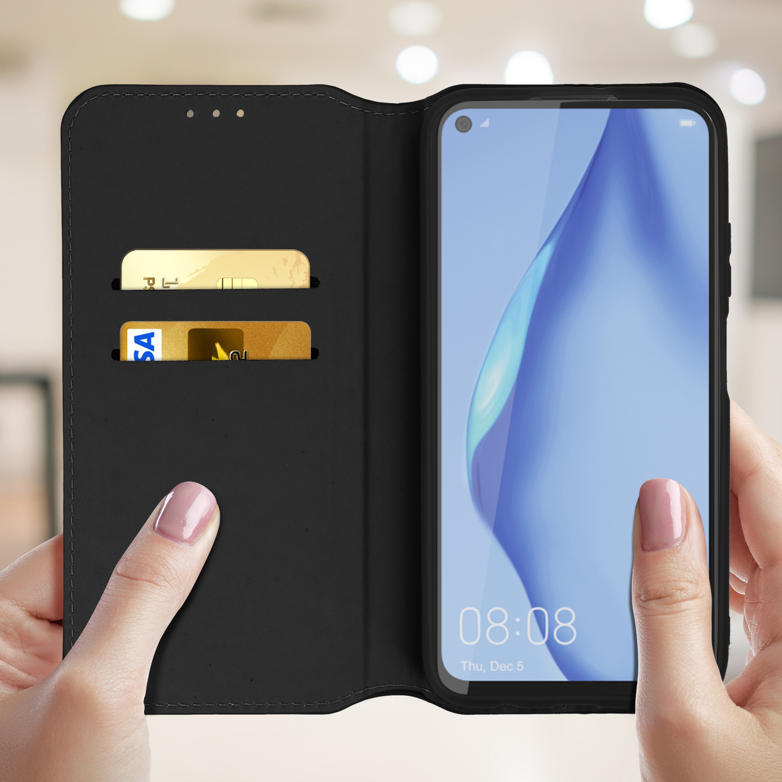 Telefono in una custodia a portafoglio nera. Due mani lo tengono aperto. Carte a sinistra.