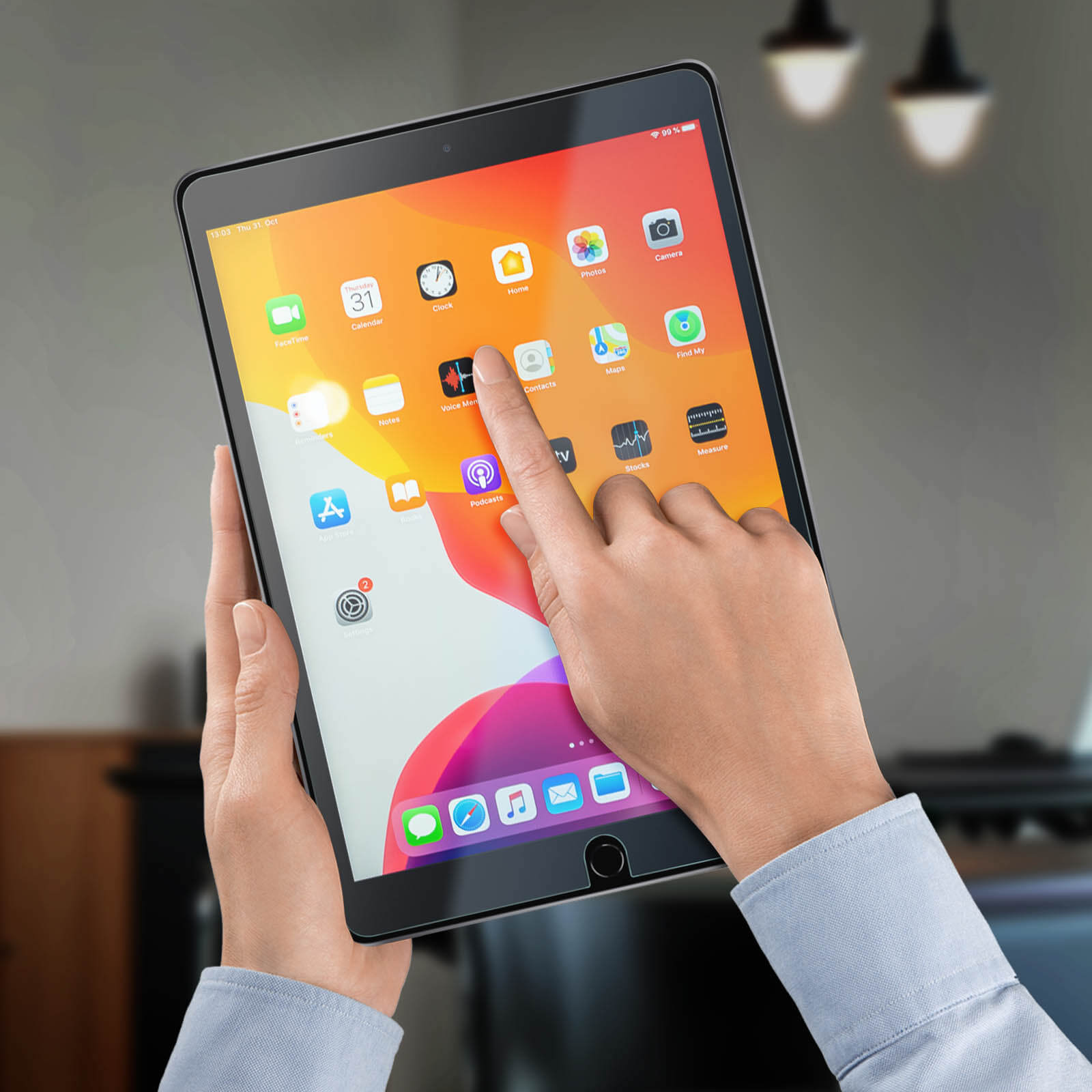 Mano che tiene un tablet con app aperte. Un dito tocca lo schermo. Sfondo sfocato.