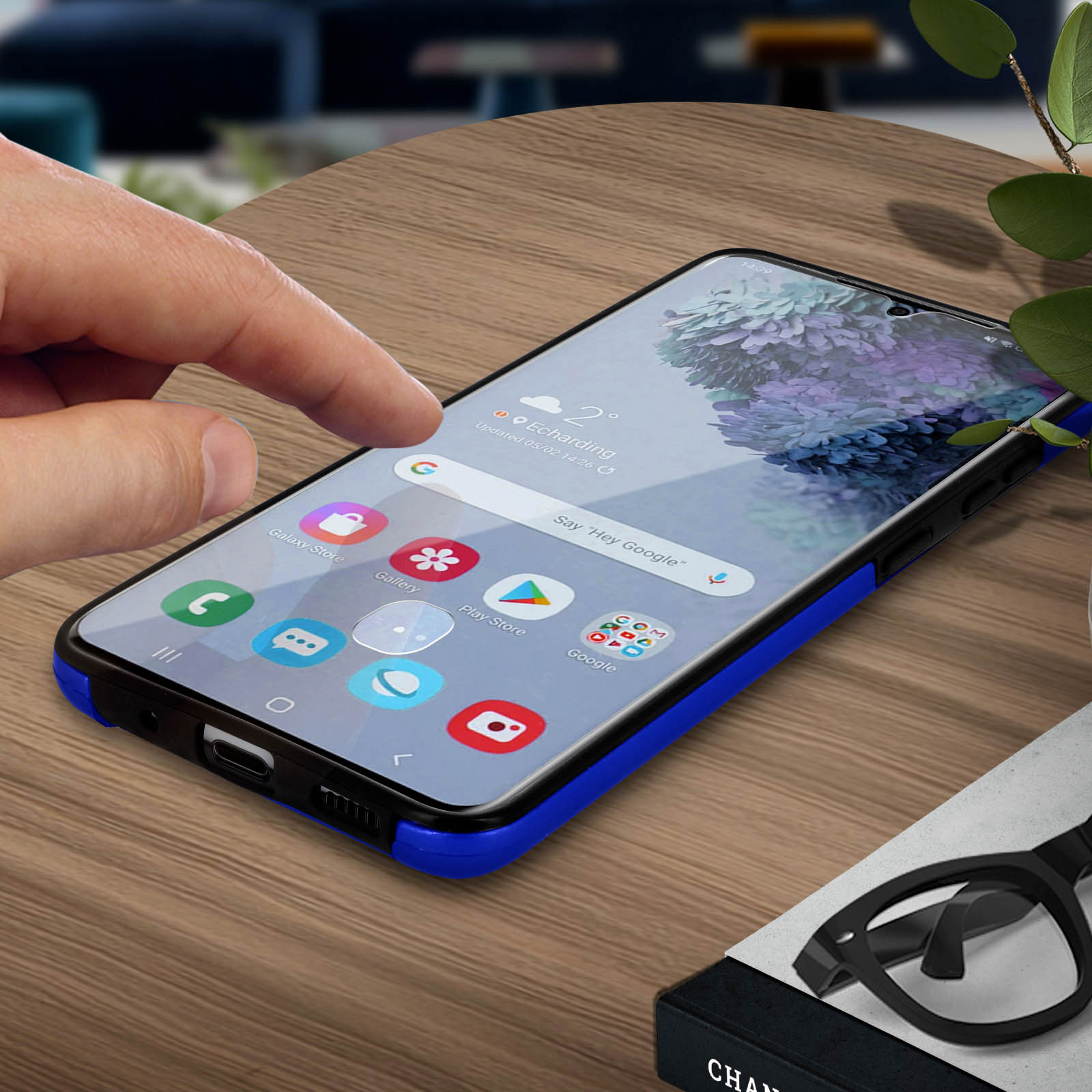 Un dito tocca lo schermo di un telefono. Lo schermo mostra una pagina di ricerca Google con icone e una custodia blu.