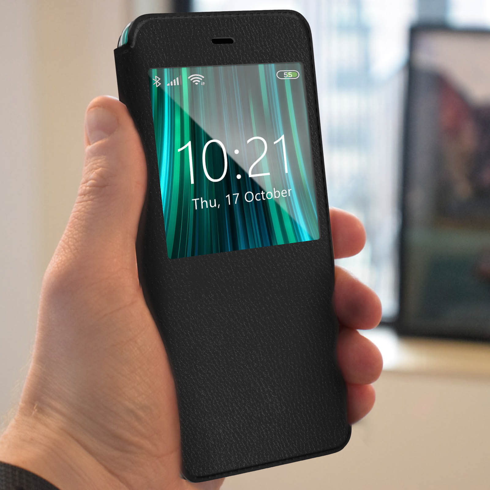 Una mano tiene uno smartphone con lo schermo che mostra l'ora e le notifiche. Il telefono è in una custodia nera.