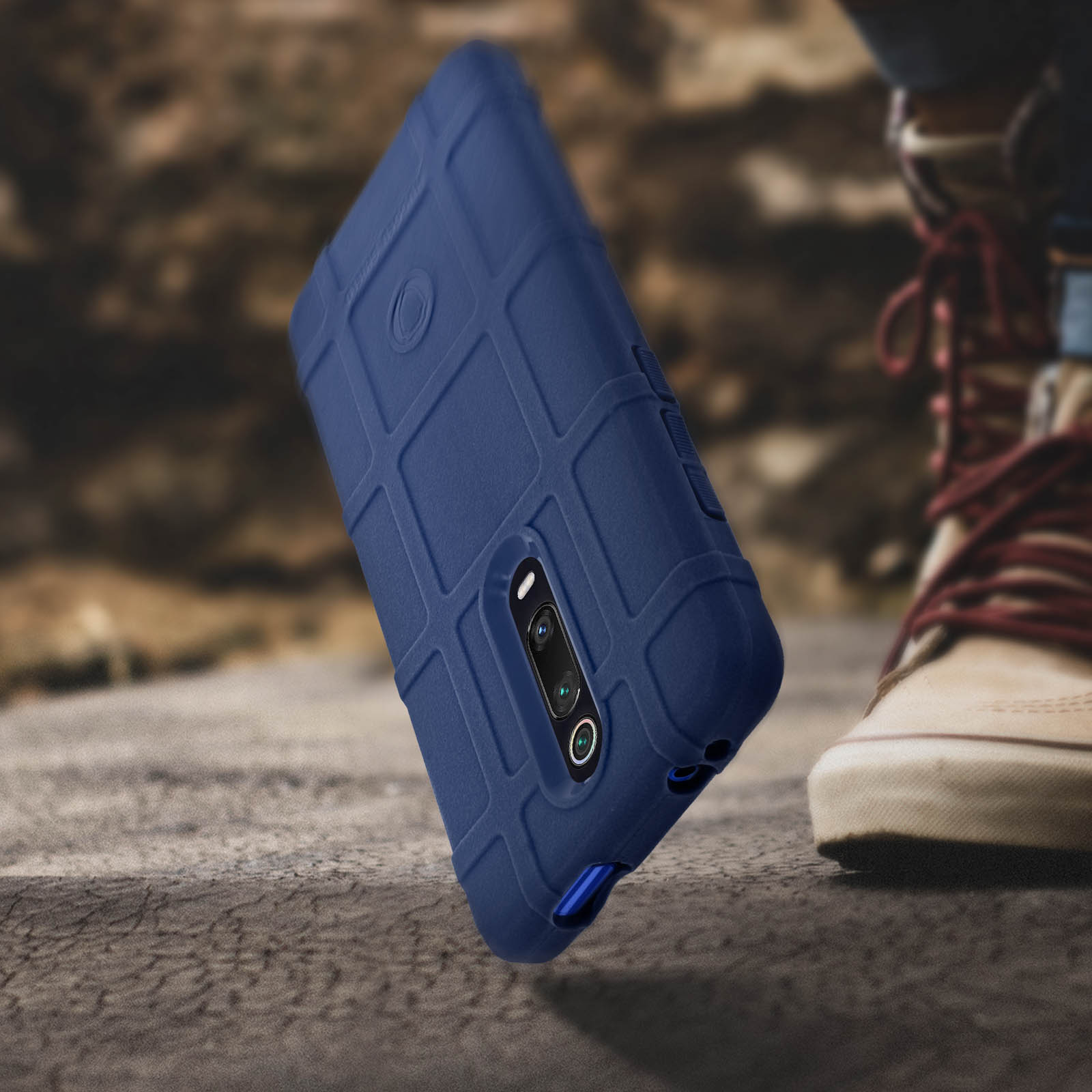 Una custodia blu per telefono su una superficie ruvida. Una scarpa è sullo sfondo.