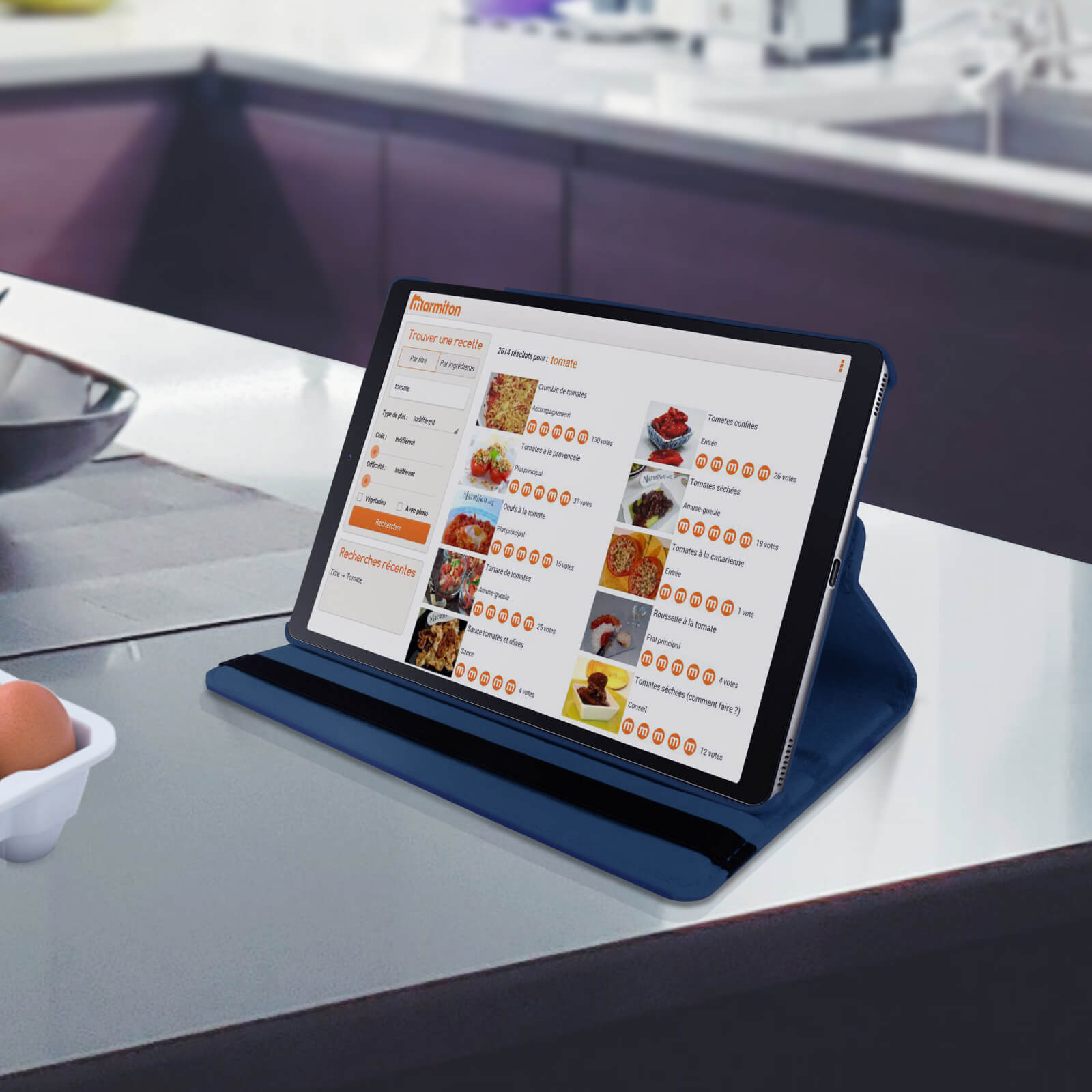Tablet in una custodia blu che mostra una ricetta. Lo sfondo è un bancone da cucina.