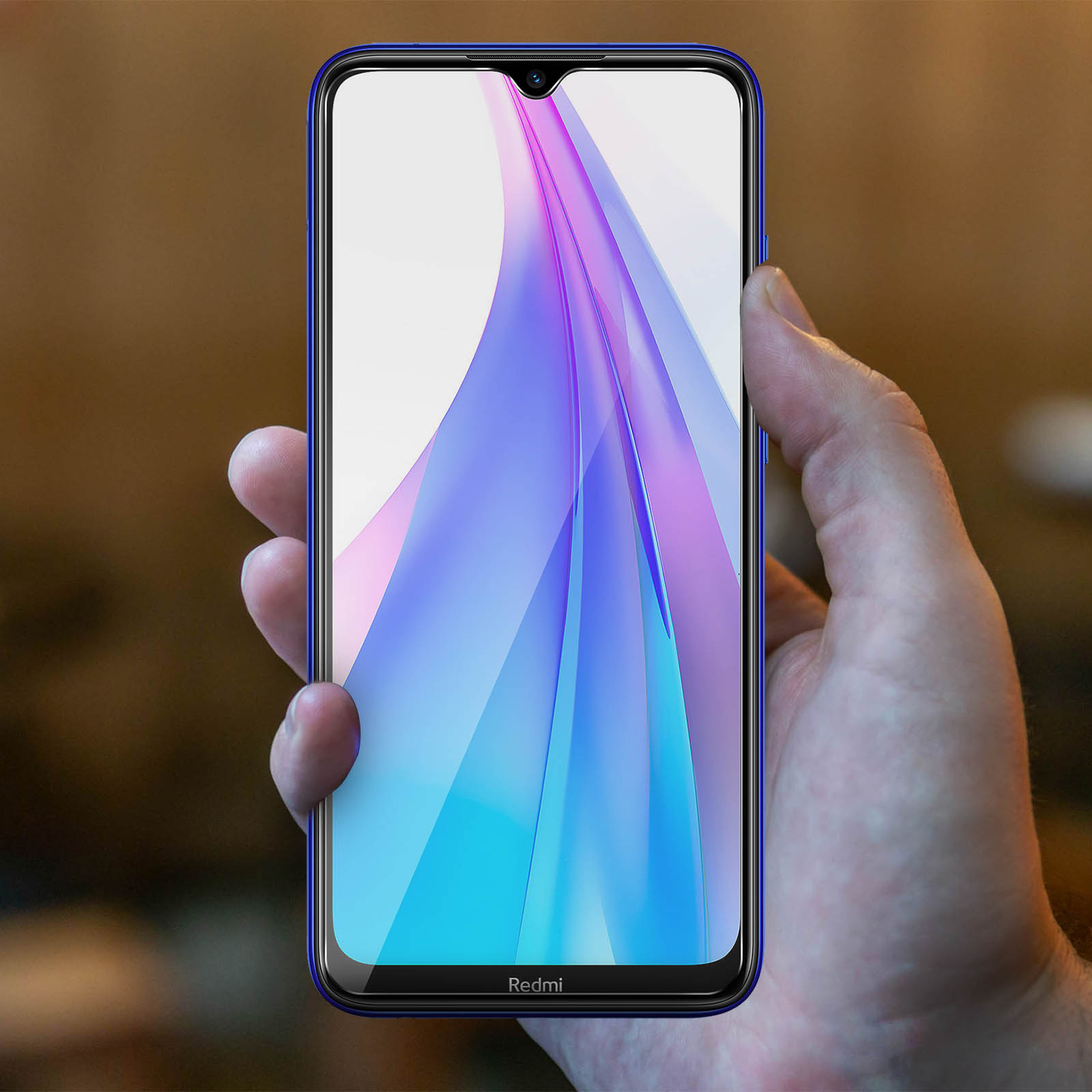 Una mano che tiene un telefono con cornice blu, il telefono mostra uno sfondo colorato.
