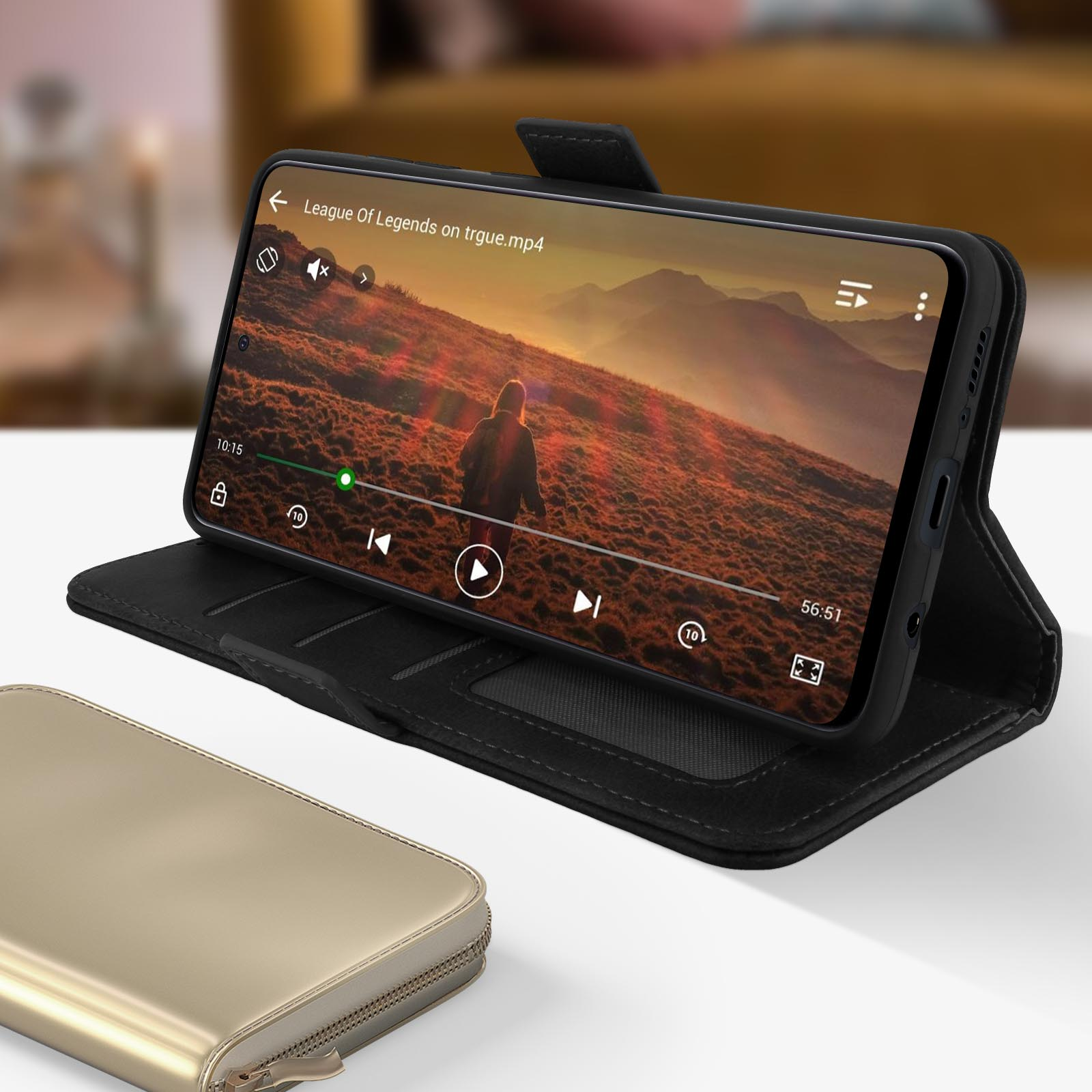 Un telefono mostra un video. Il telefono è in una custodia nera su un tavolo di legno.