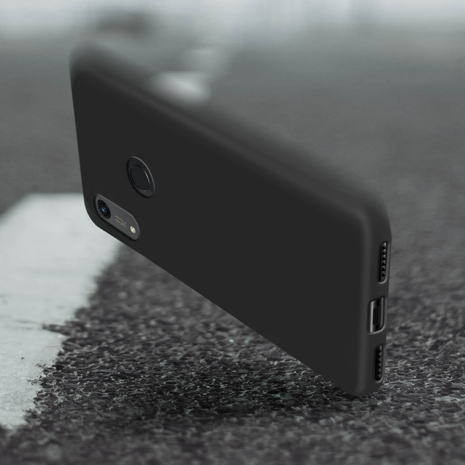 Custodia nera per telefono su superficie grigia strutturata, leggermente angolata.