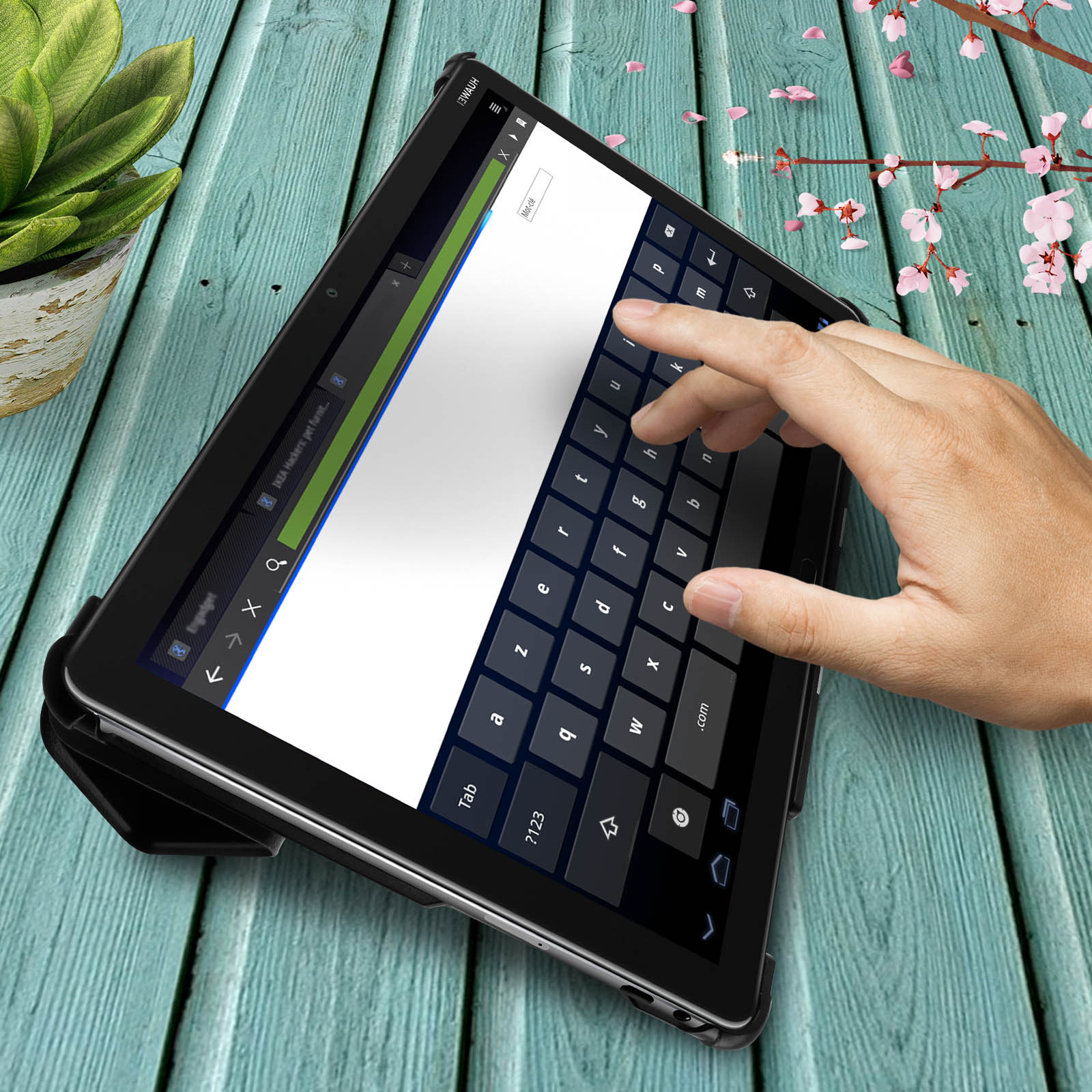 Tablet su superficie in legno. Mano tocca la tastiera. Tastiera e fiori sullo sfondo.