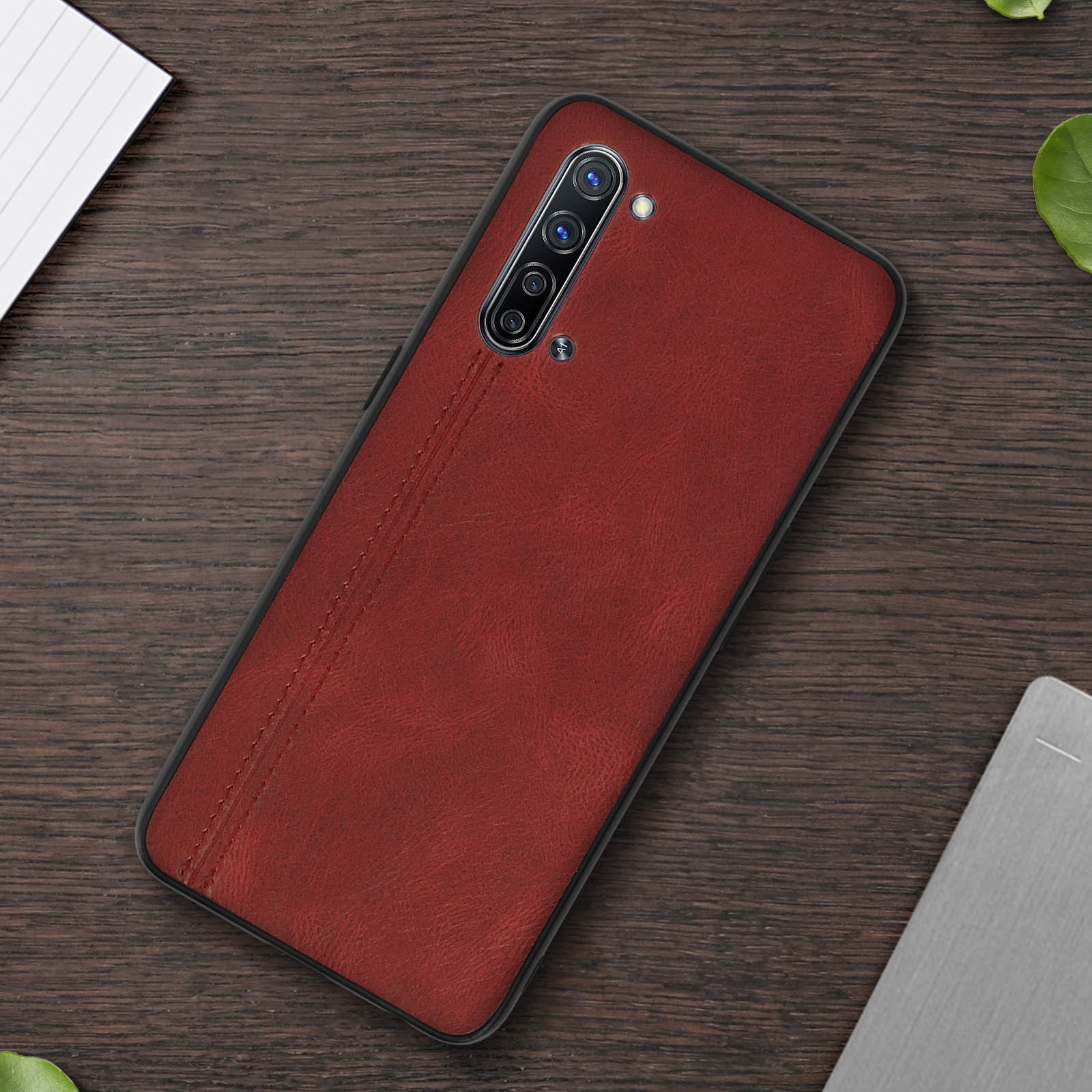 Custodia per telefono in pelle rossa con cornice nera, cuciture e fotocamere.