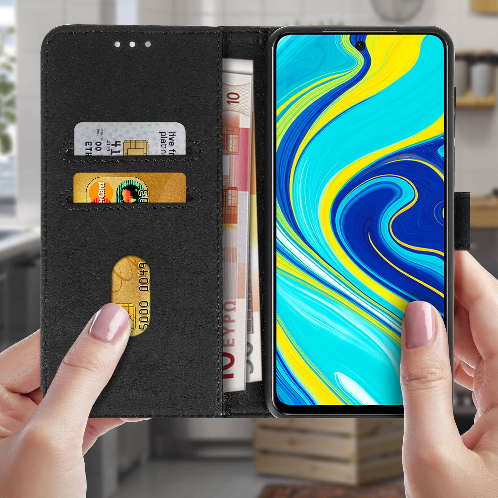 Mani che tengono aperta una custodia nera per telefono. All'interno ci sono soldi e carte di credito.