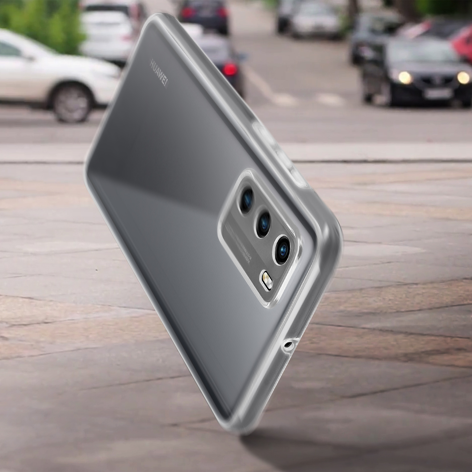Transparante telefoonhoes, toont de achterkant van de telefoon op een weg. Auto's onscherp op de achtergrond.