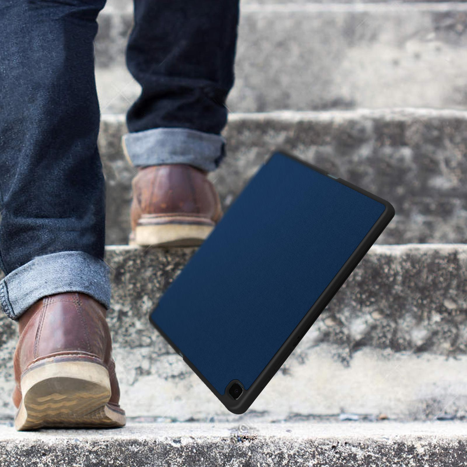 Eine Tablethülle auf einer Treppe. Eine Person geht die Treppe hoch. Blaue Hülle.