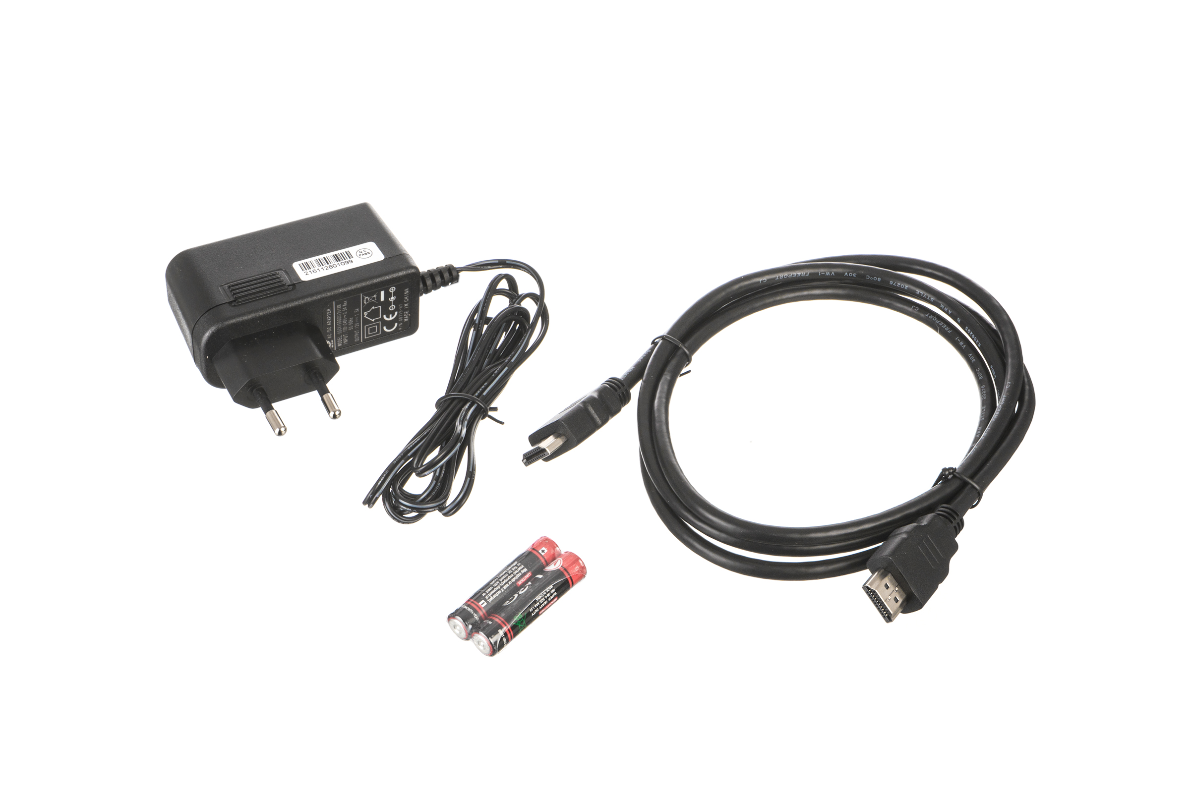 Ein Netzteil, ein HDMI-Kabel, ein USB-Kabel und zwei Batterien auf weißem Hintergrund.
