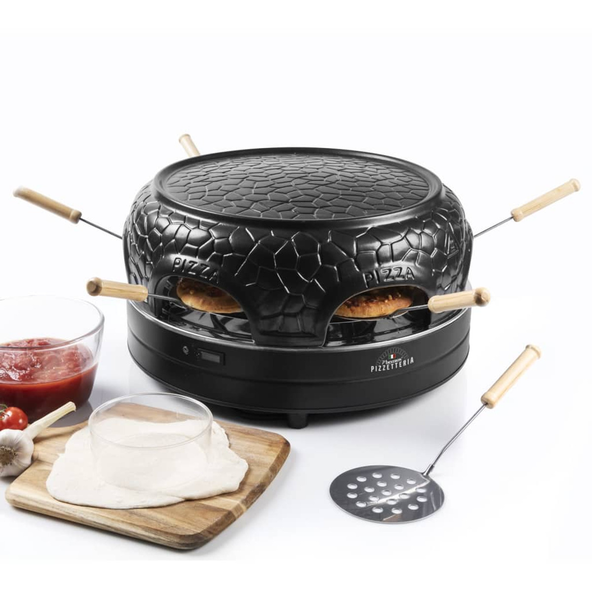 Un forno per pizza nero con due pizze all'interno, con ingredienti intorno.