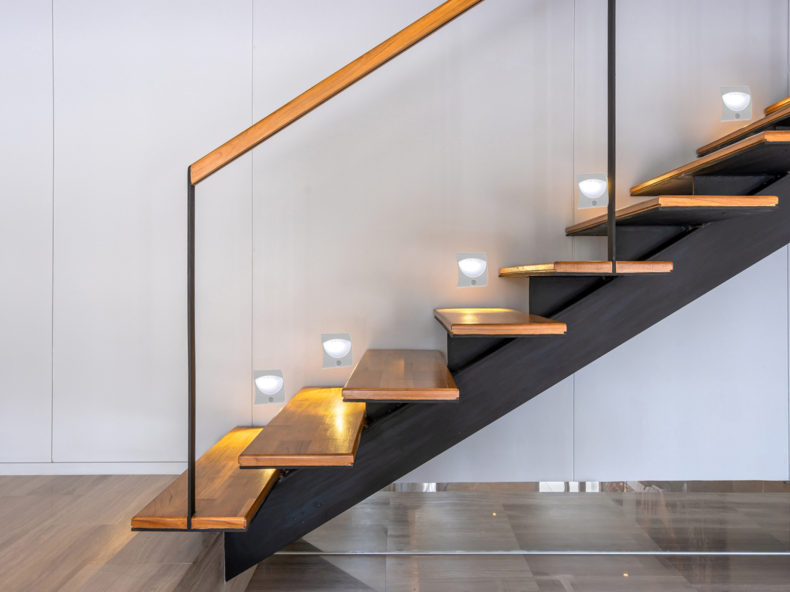Treppe mit Lichtern und schwarzem und hölzernem Handlauf.