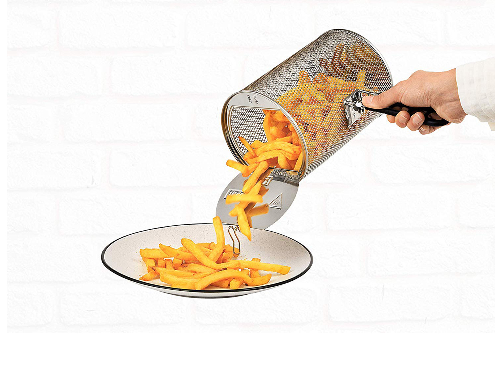 Papas fritas vertiéndose de una canasta de metal a un plato.