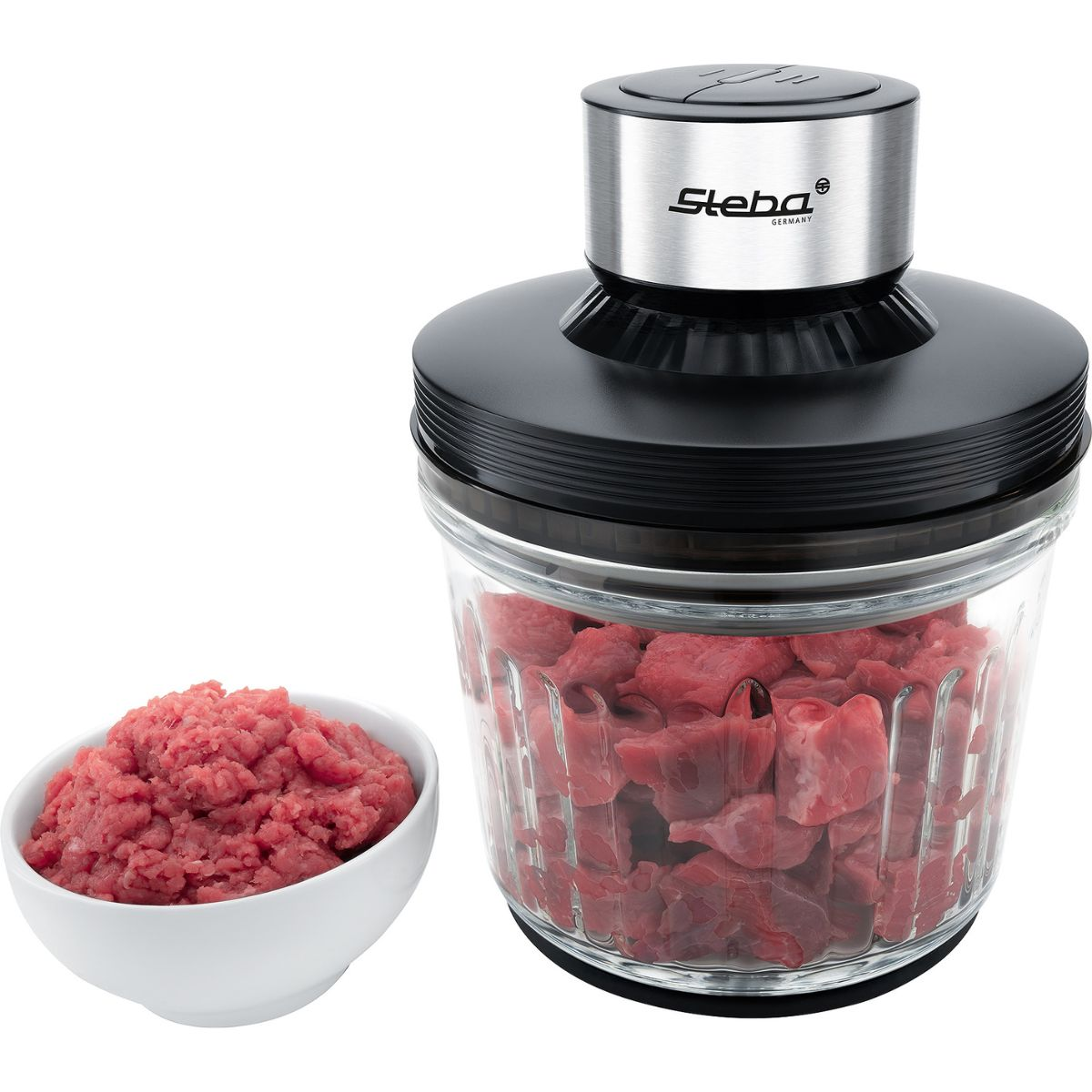 Un robot da cucina pieno di carne e una piccola ciotola di carne macinata a sinistra.