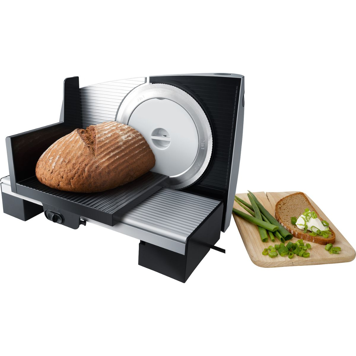 Un'affettatrice per pane con una pagnotta e una fetta con condimenti su un tagliere.