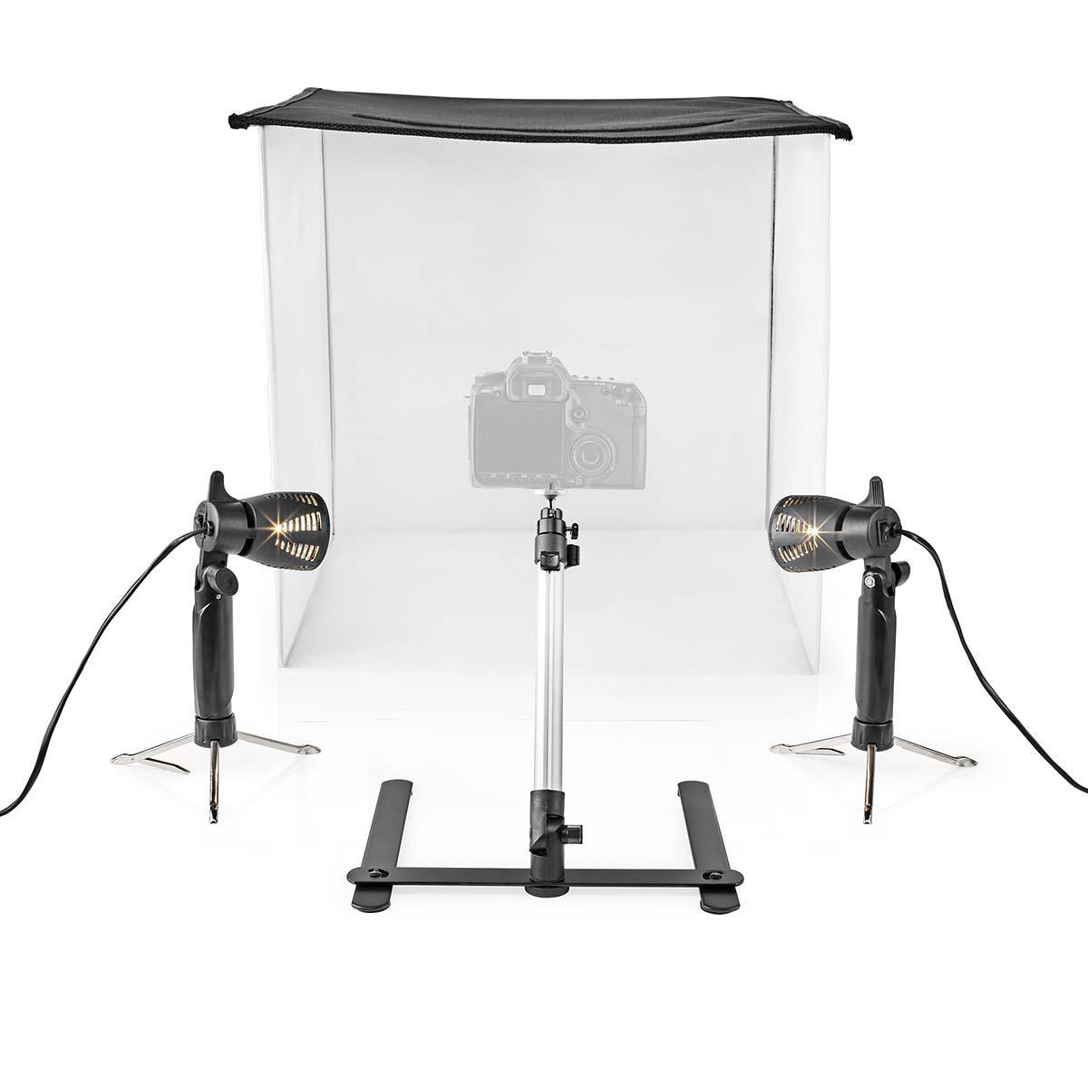 Een fotostudio-opstelling met een camera, twee lampen en een witte achtergrond in een kubusvormig frame.