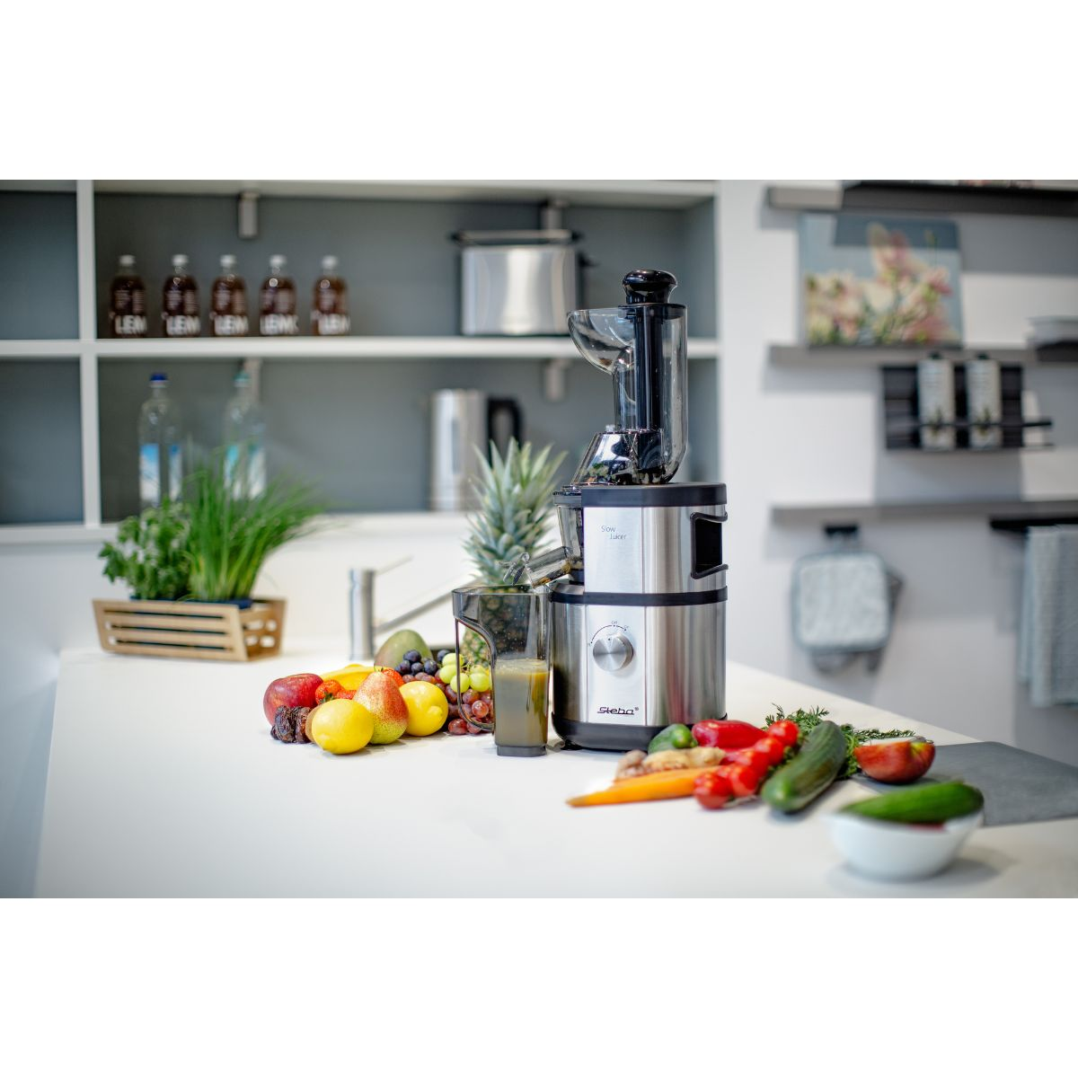 Una escena de cocina con una licuadora y frutas en una encimera blanca.