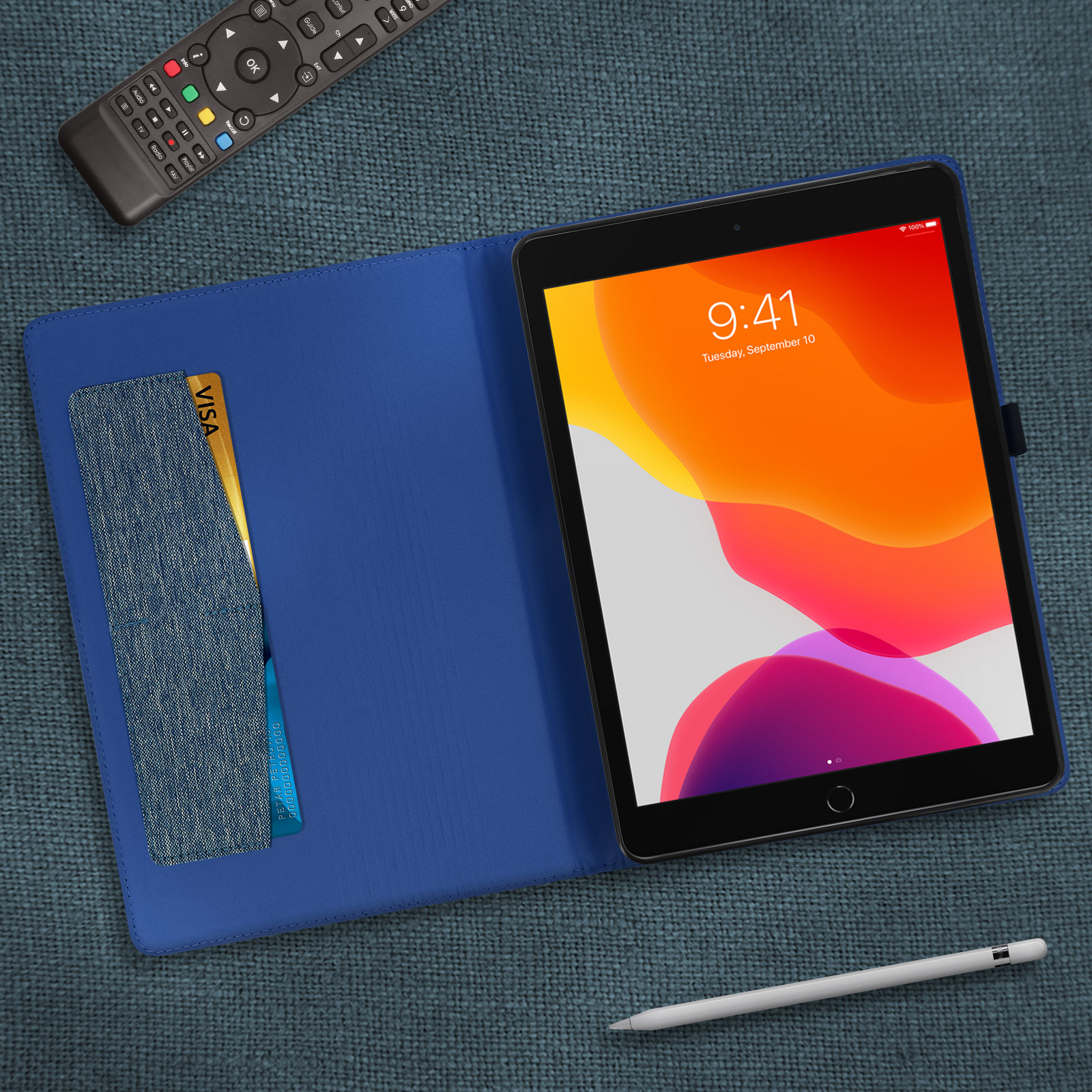 Custodia blu per tablet con coperchio aperto. Tablet con visualizzazione dell'ora e carta di credito. Superficie blu.