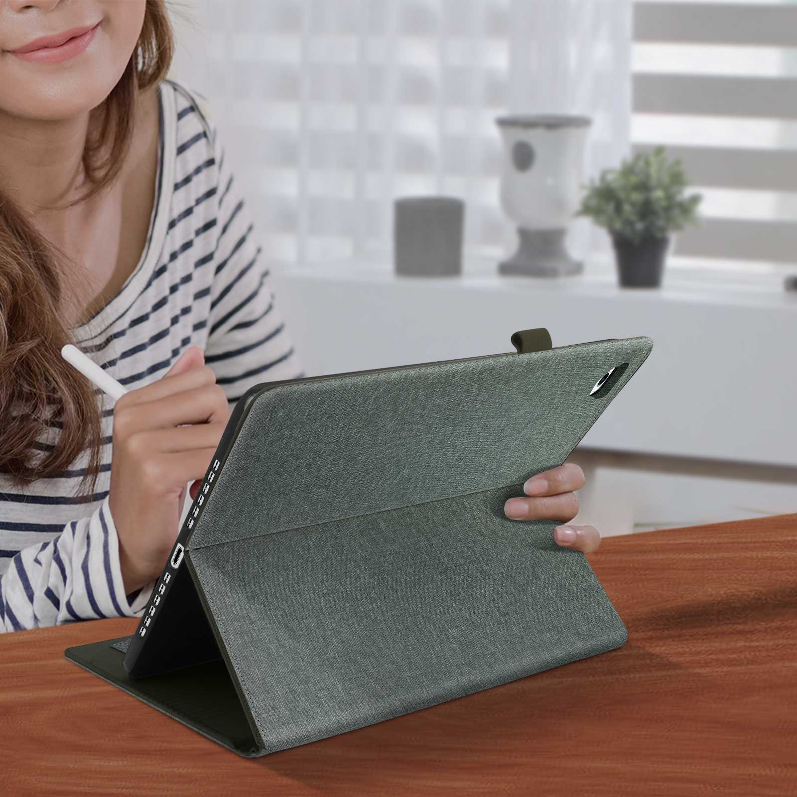Persona che usa un tablet con custodia protettiva su un tavolo.