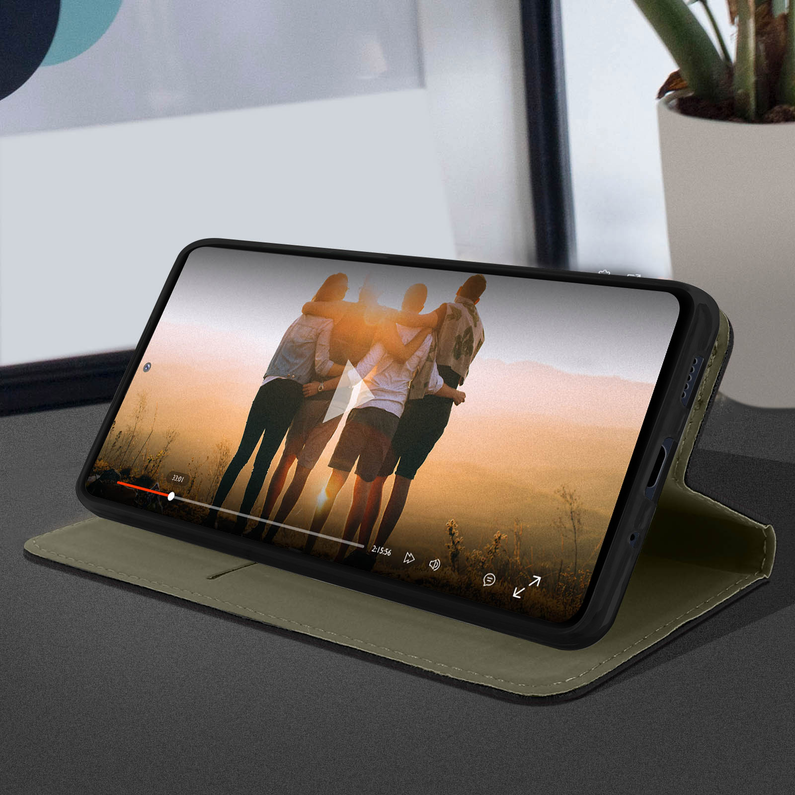 Telefoon in een hoesje, speelt een video af. Mensen op het scherm.
