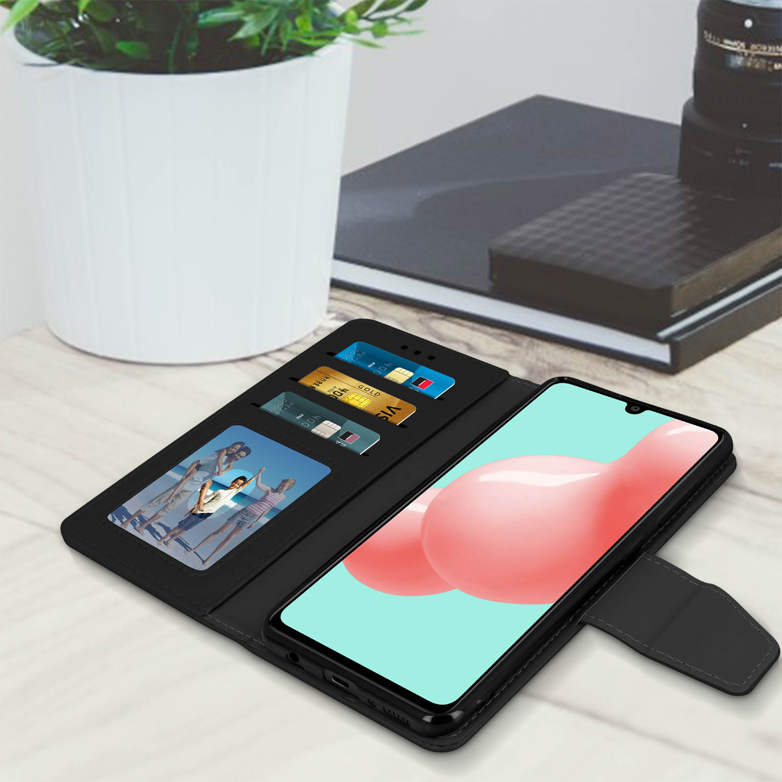 Custodia per telefono aperta con carte di credito e una foto. Uno schermo del telefono è a destra.