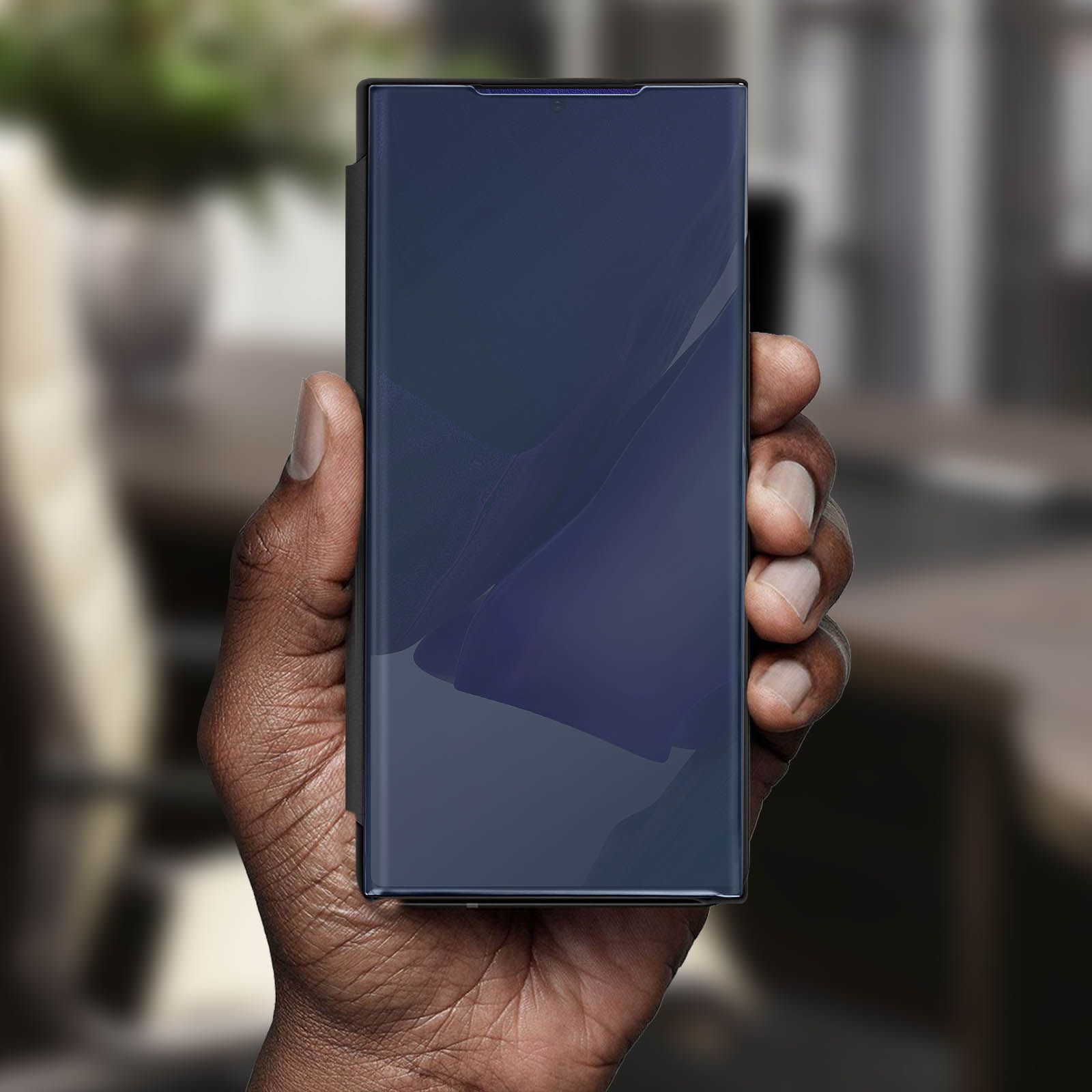 Una mano tiene in mano un telefono blu scuro, il cui schermo è acceso, mostrando un design blu e viola.