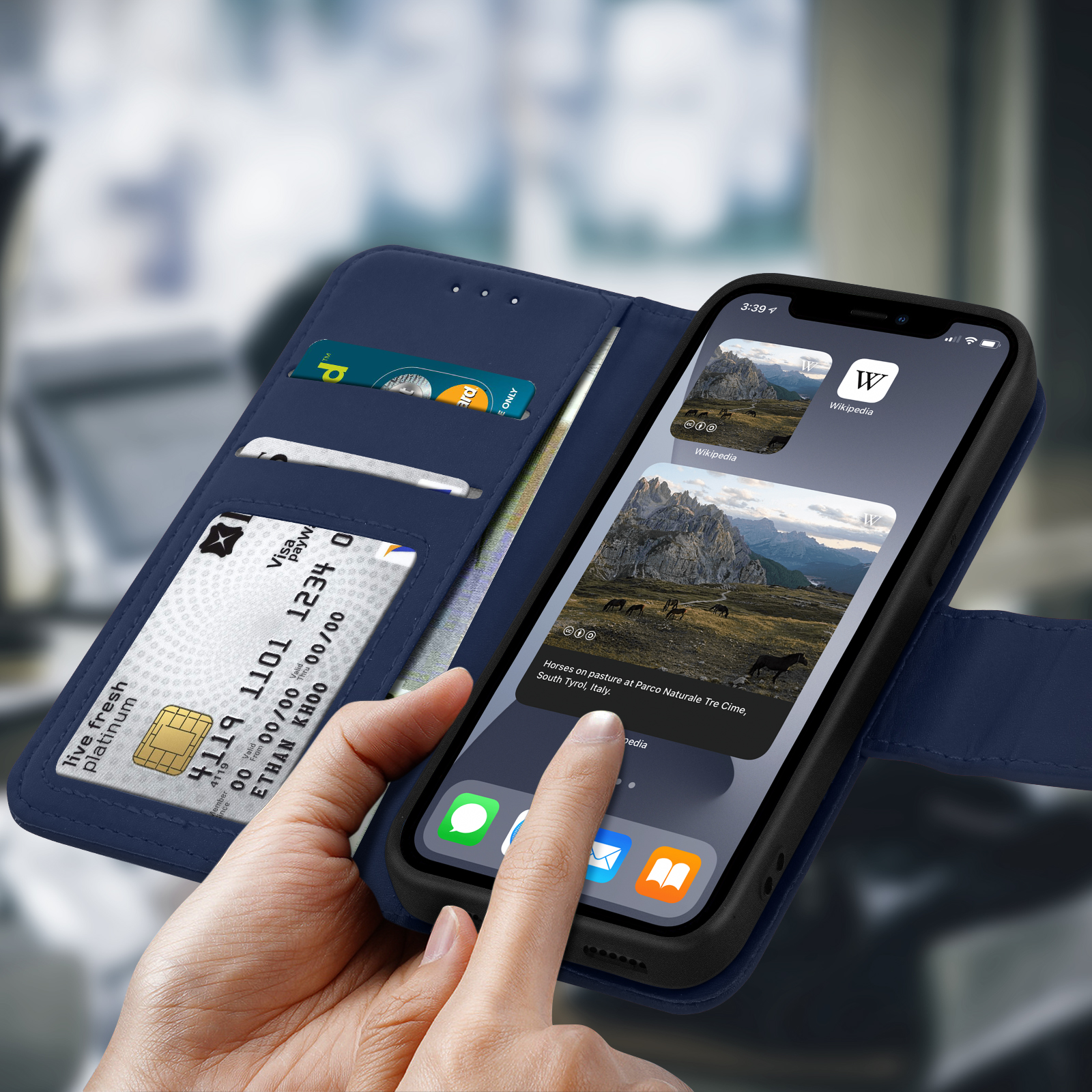 Un telefono in custodia blu, portafoglio aperto con carte. Una mano tocca lo schermo.