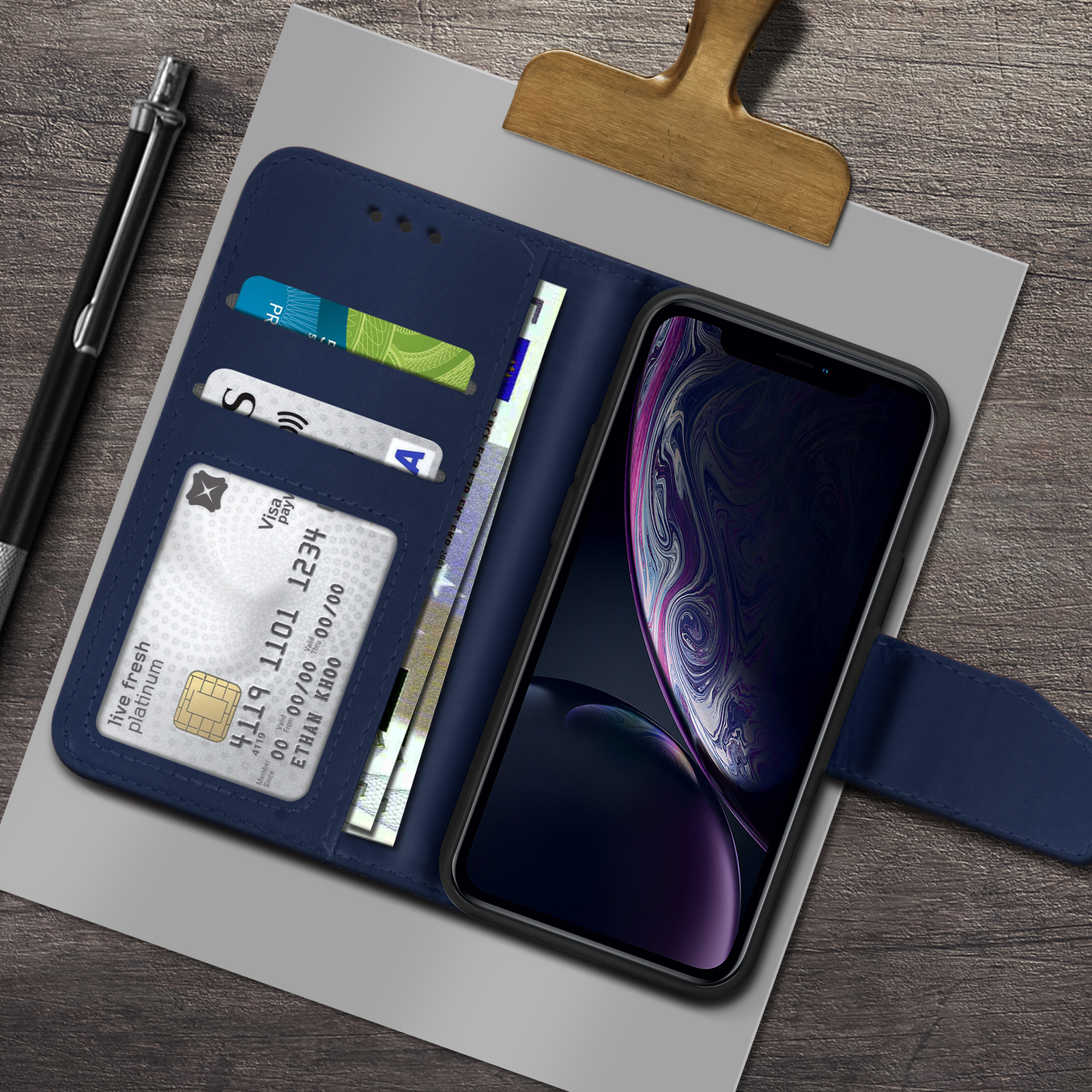Una custodia per telefono blu scuro è aperta, che mostra carte e contanti. Il telefono ha uno schermo colorato.
