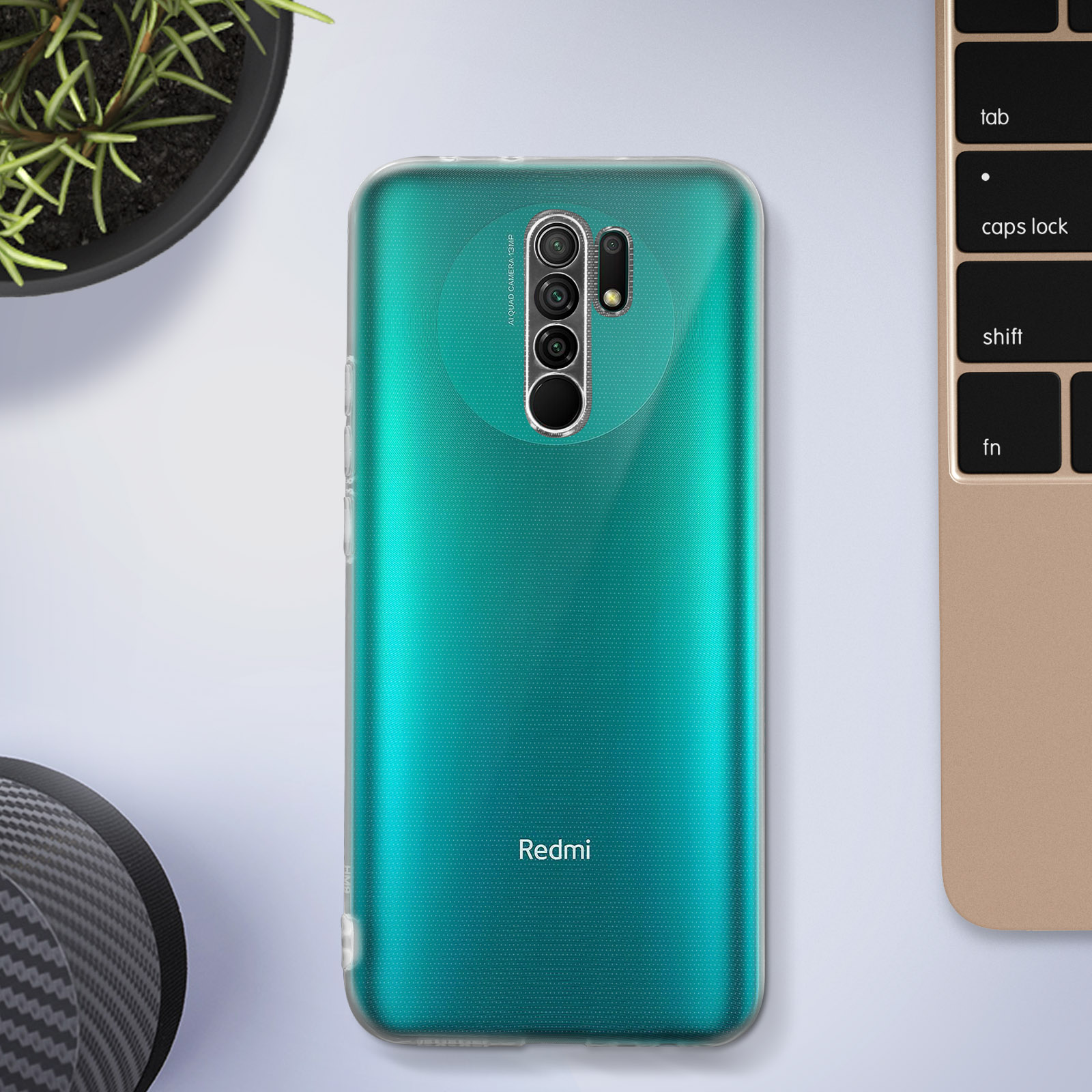 Groene telefoonhoes op een licht oppervlak, in de buurt van een toetsenbord en een zwarte hoed.