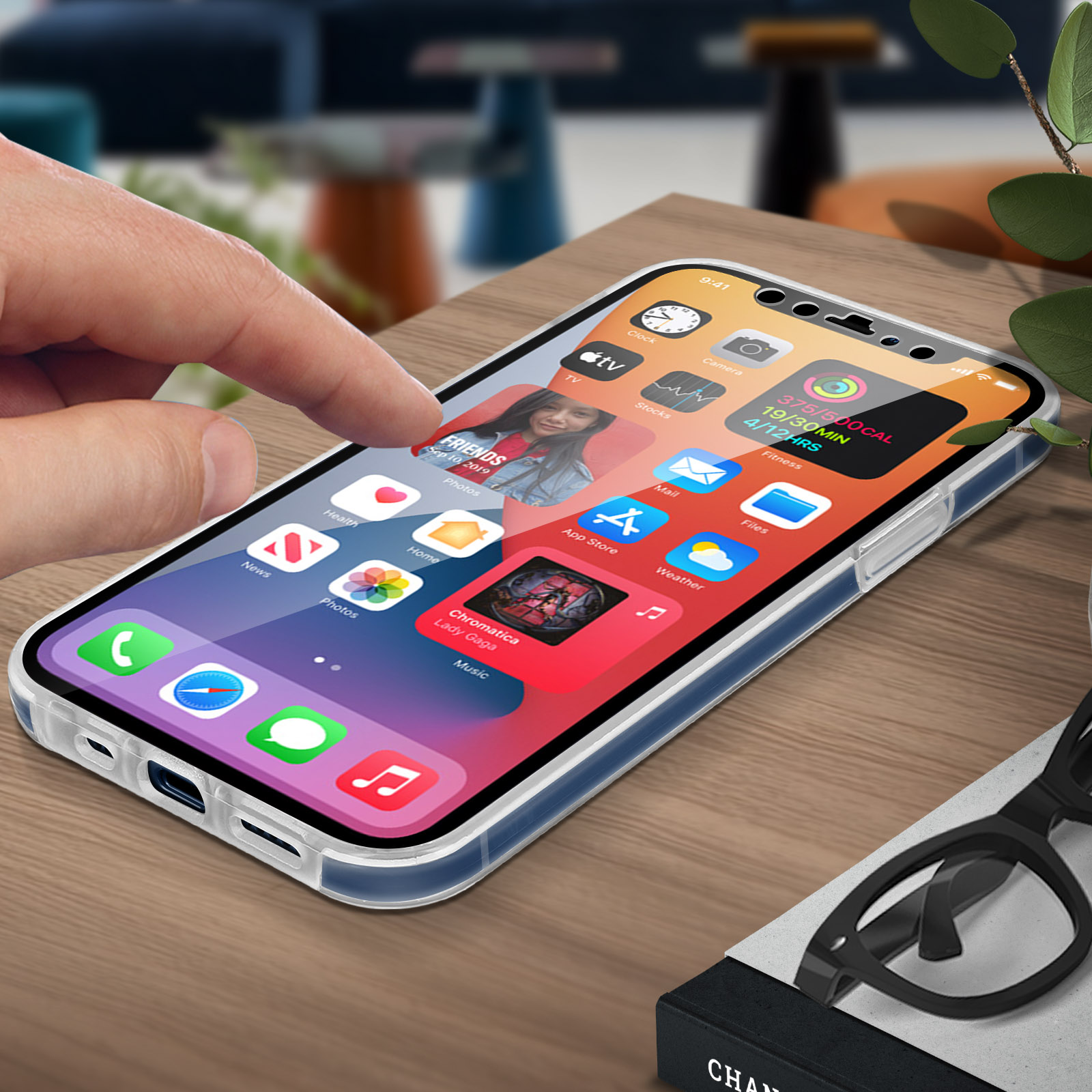 De vinger van een persoon raakt een telefoonscherm met apps. Een bril en een boek in de buurt.